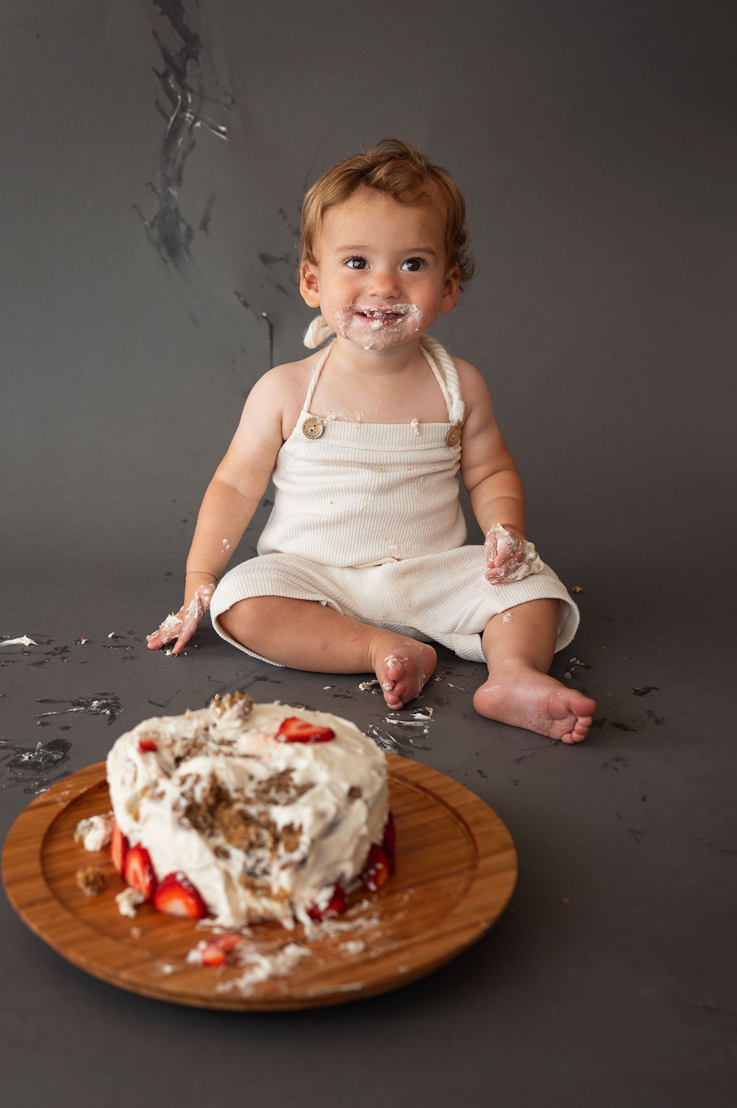 Cake smash milestone session at Curate Studios in New Albany—baby smiling with frosting-covered face