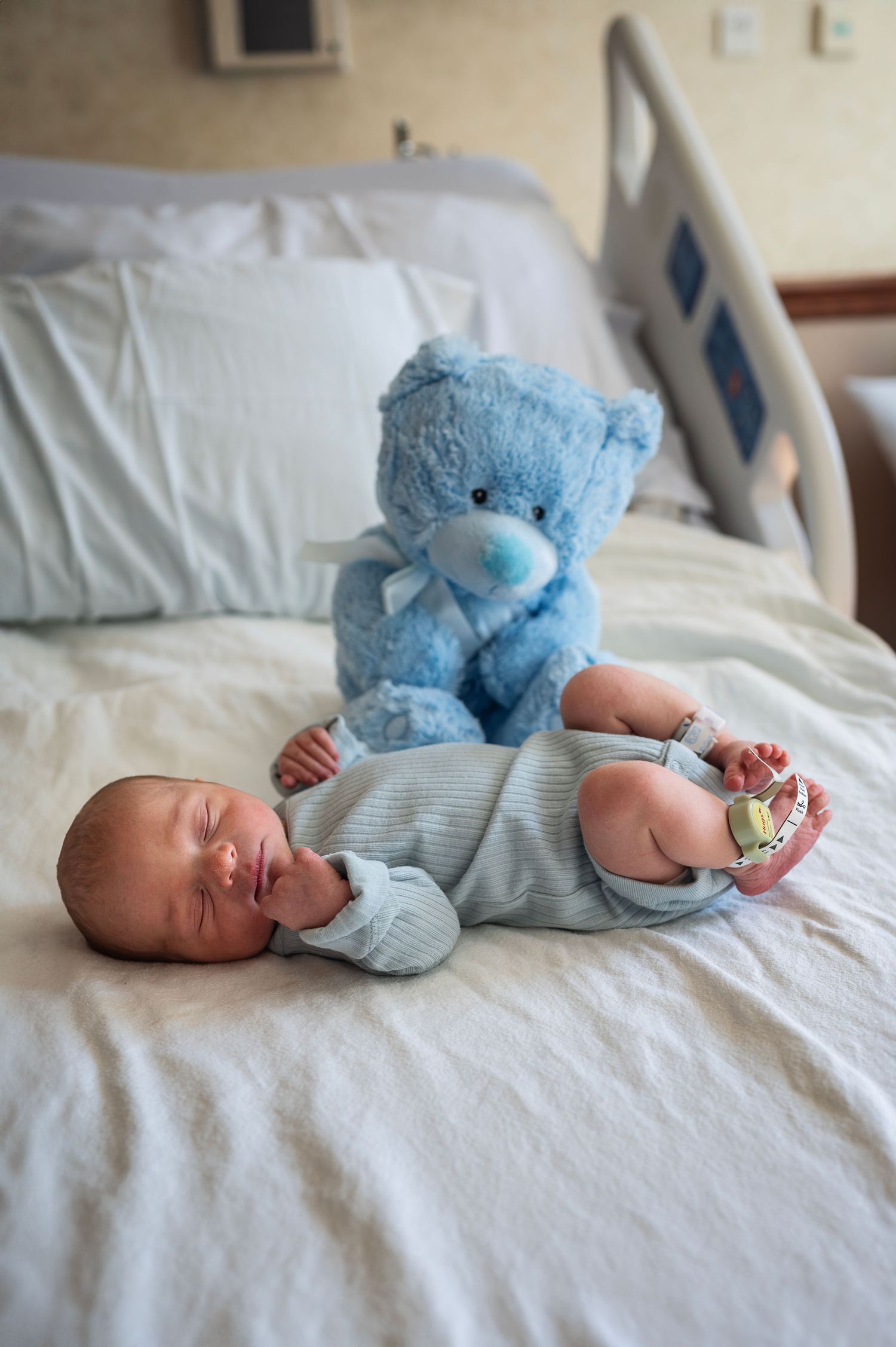 A tiny miracle in soft blue lies curled beside his very first friend. Captured during a Fresh 48 session by Westerville newborn photographer