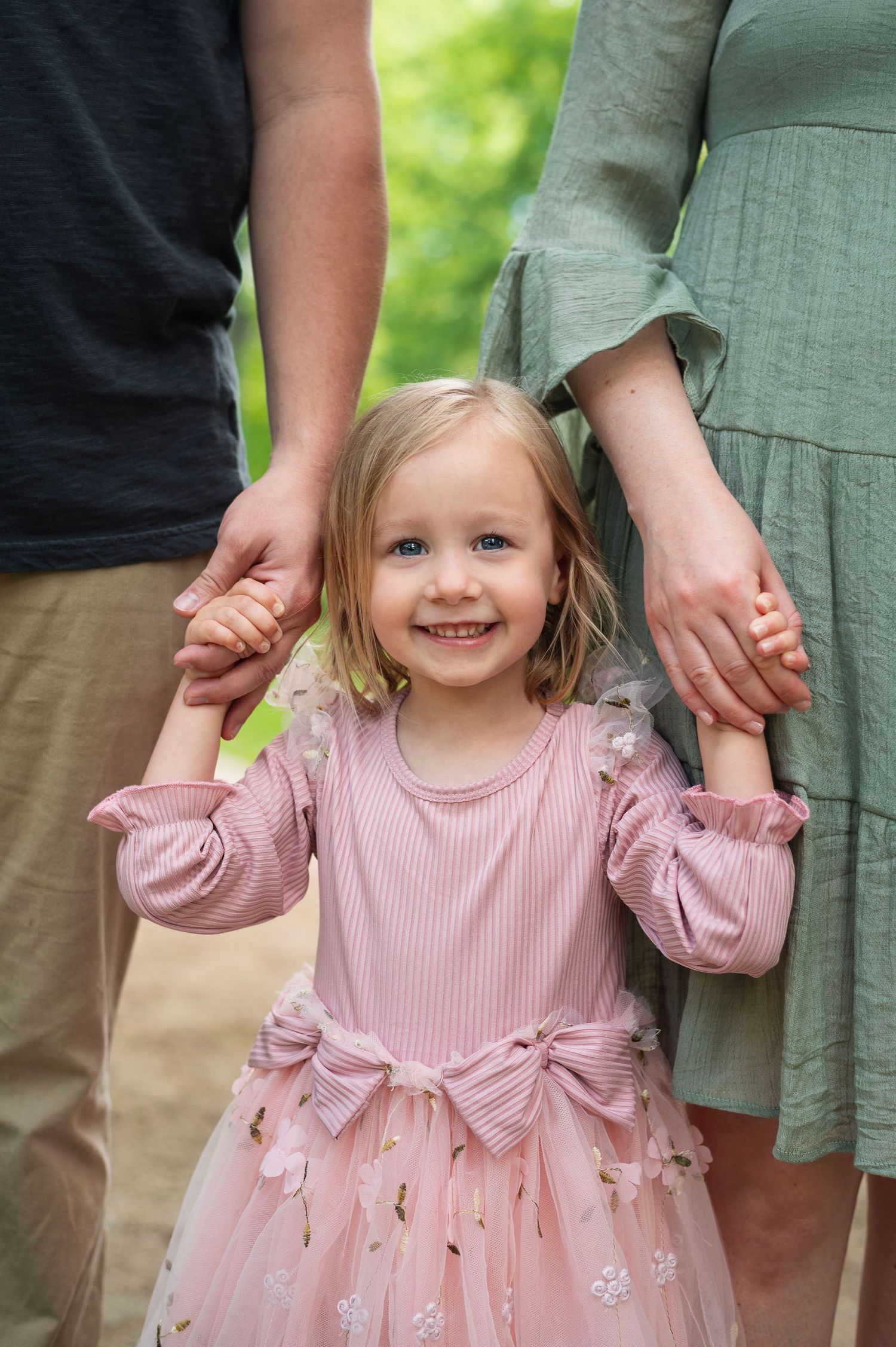 Little girl holding hands with parents during spring family photo—Westerville family photographer