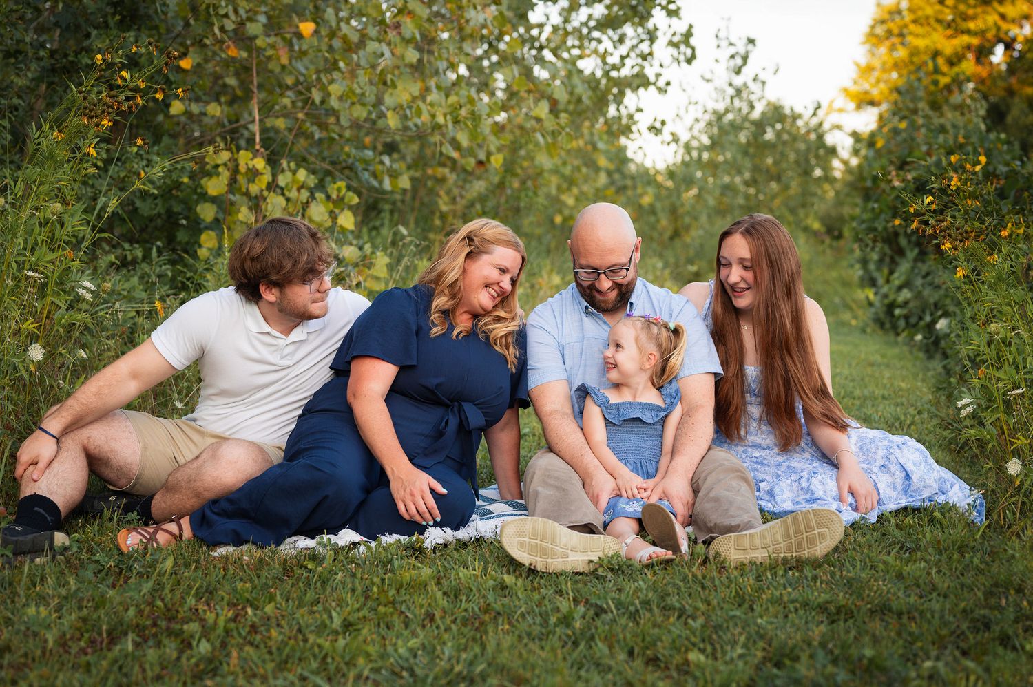 Laughter, sunlight, and siblings side by side—just one big happy crew soaking in golden hour joy.