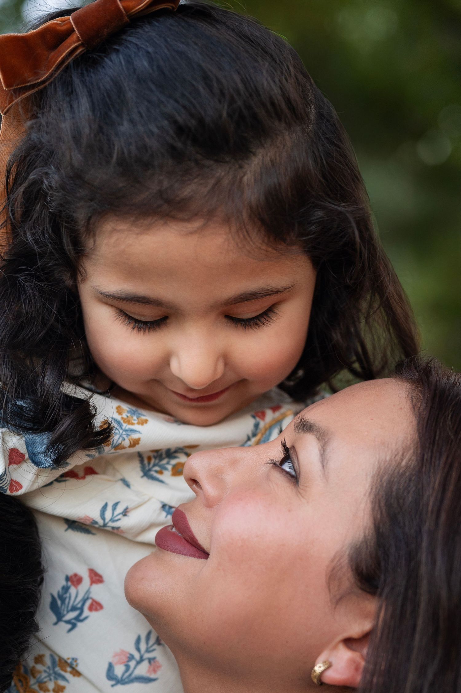Mom and younger daughter share a quiet forehead-to-forehead moment during their tea party session in Westerville, Ohio.