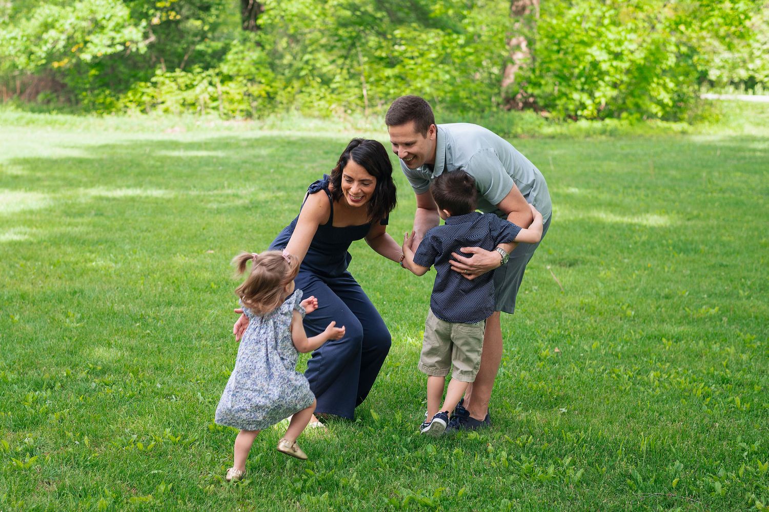 Playful family moment in the park—parents hugging kids in joyful Highbanks Metro Park family session near Westerville