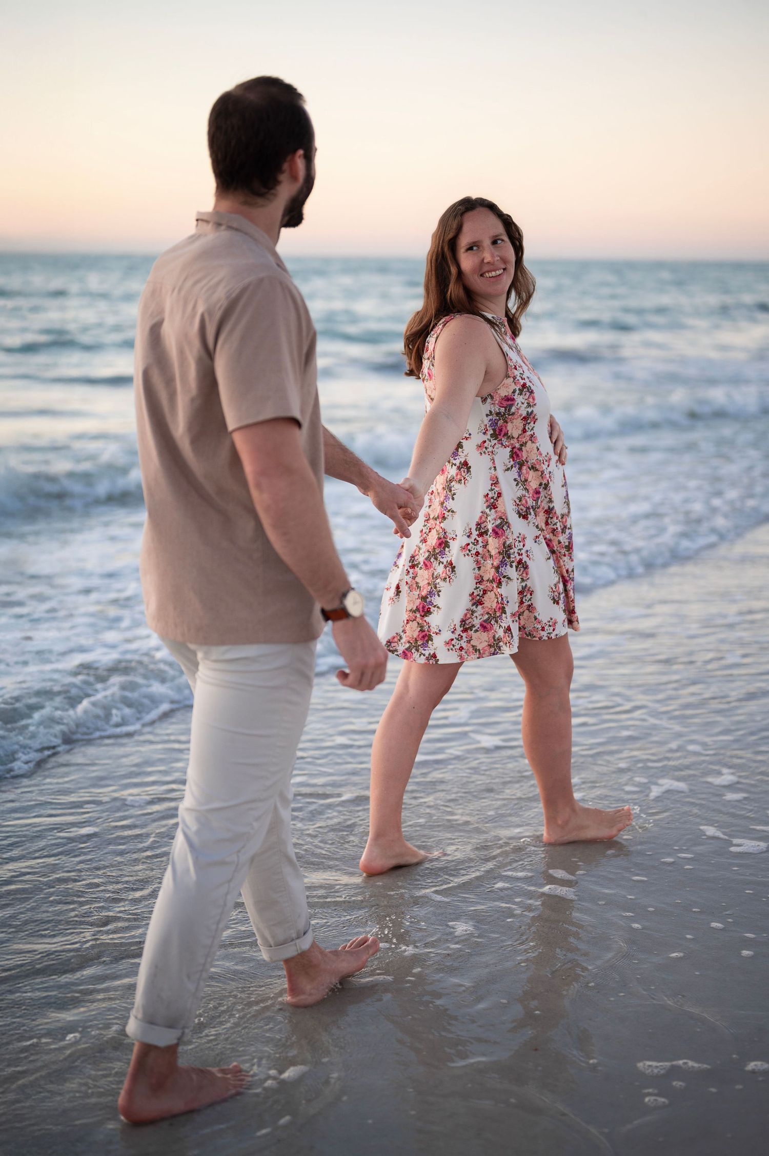 Beach maternity session at sunset, capturing connection, joy, and the beauty of pregnancy in a relaxed, lifestyle setting.