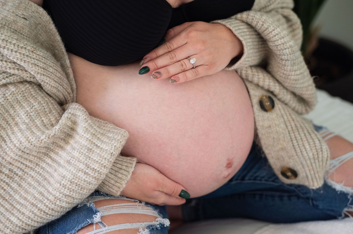 Close-up maternity session showing a mama’s hands on her belly. Captured by Westerville maternity photographer.