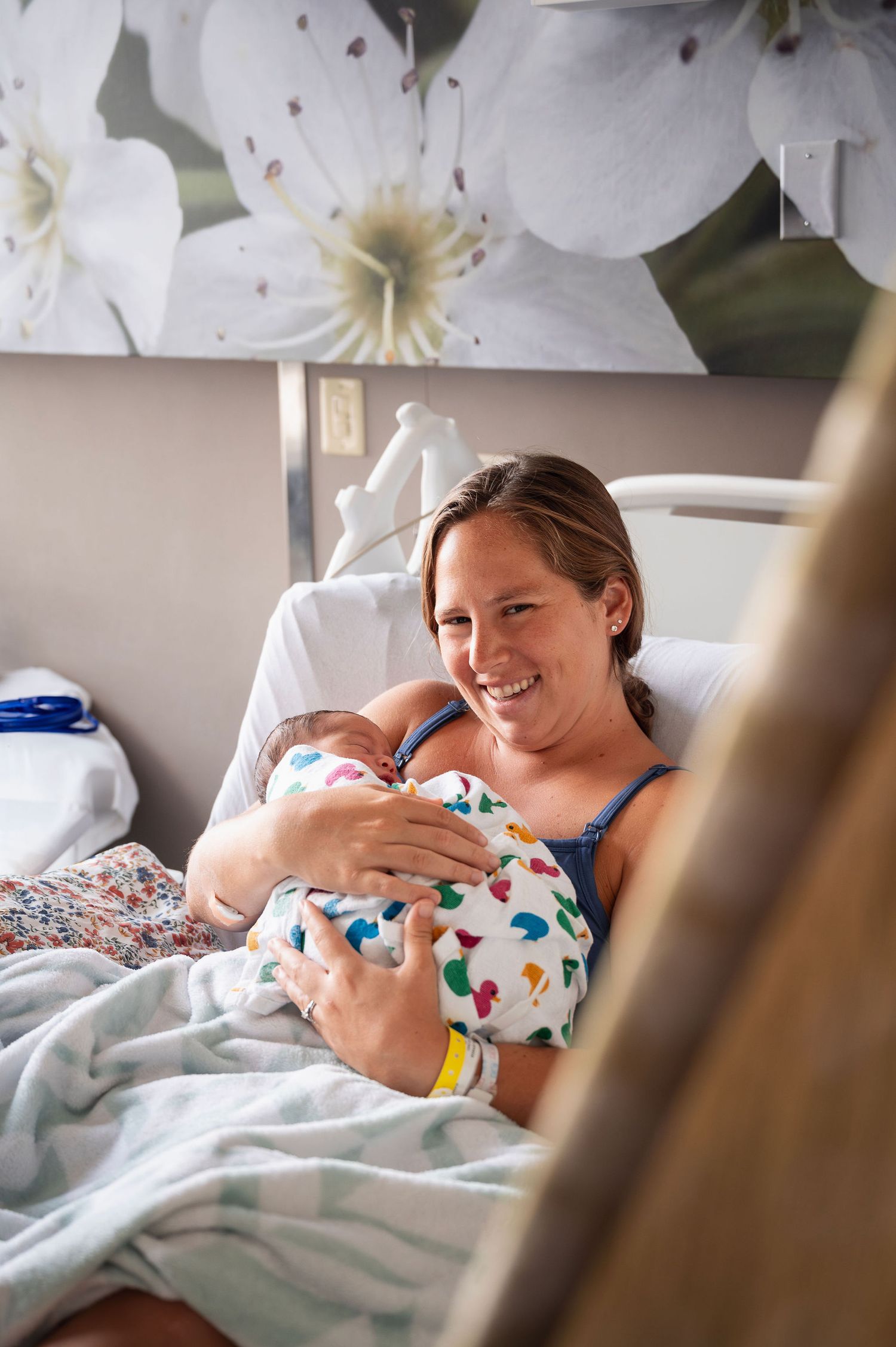 Fresh 48 session in Columbus hospital—mom smiling while cradling newborn in recovery bed