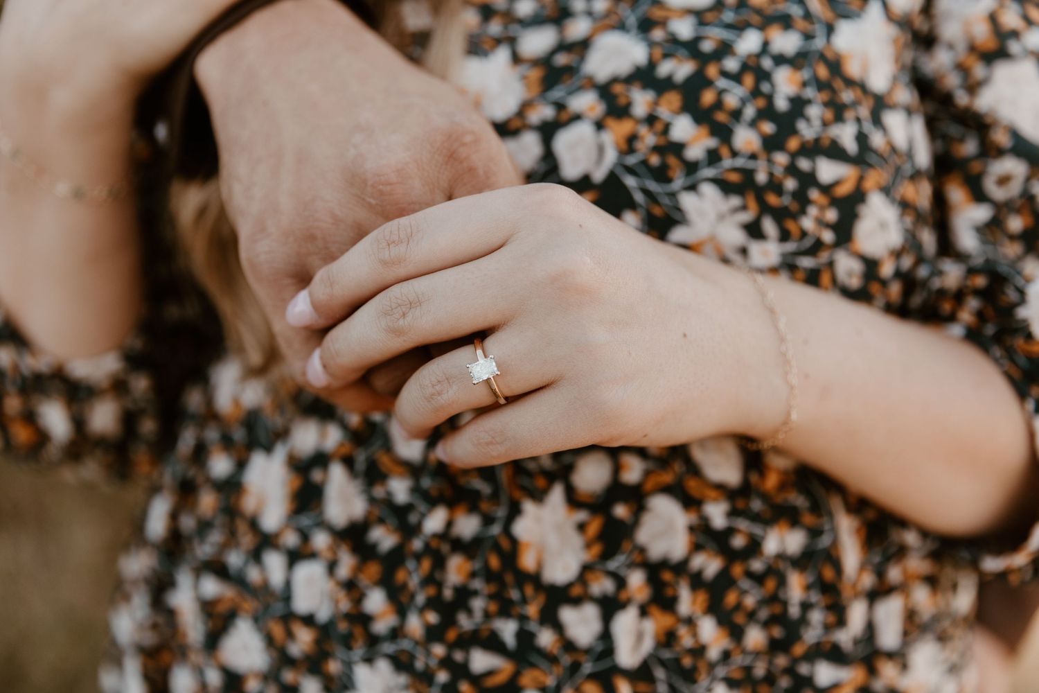 Close-up of hands holding small pebbles and stones on a rocky beach surface.