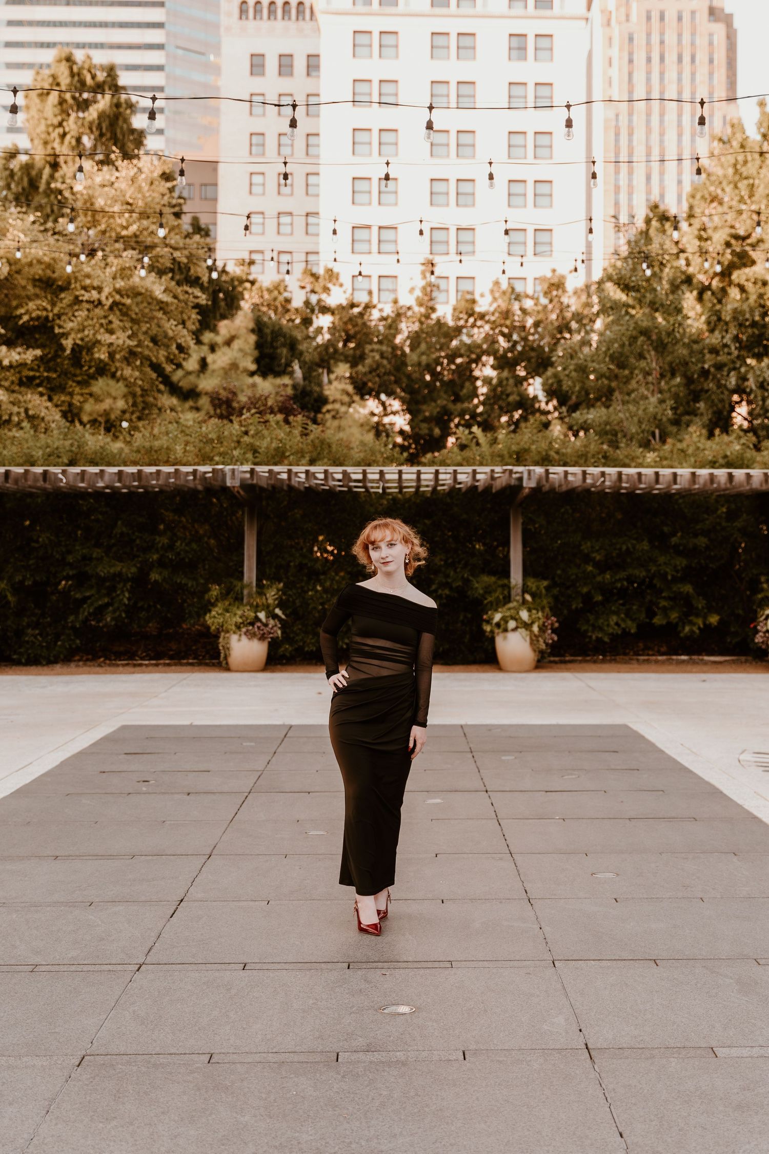 Three connected photos show a figure in a black dress twirling gracefully on an outdoor concrete terrace with buildings in background.
