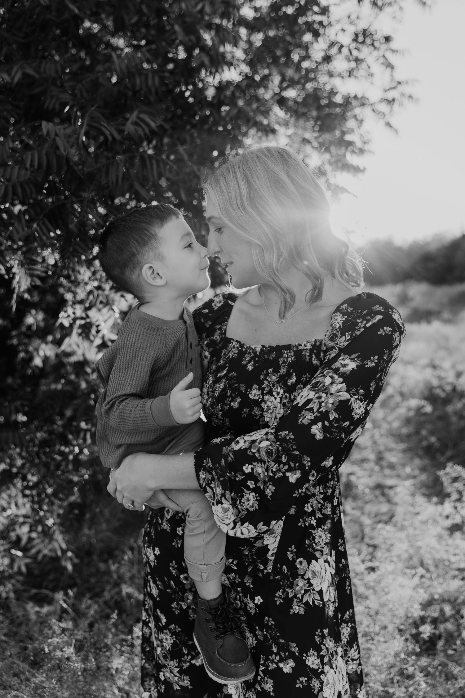 Black and white photo sequence showing tender interaction between parent and child in a blooming garden setting.