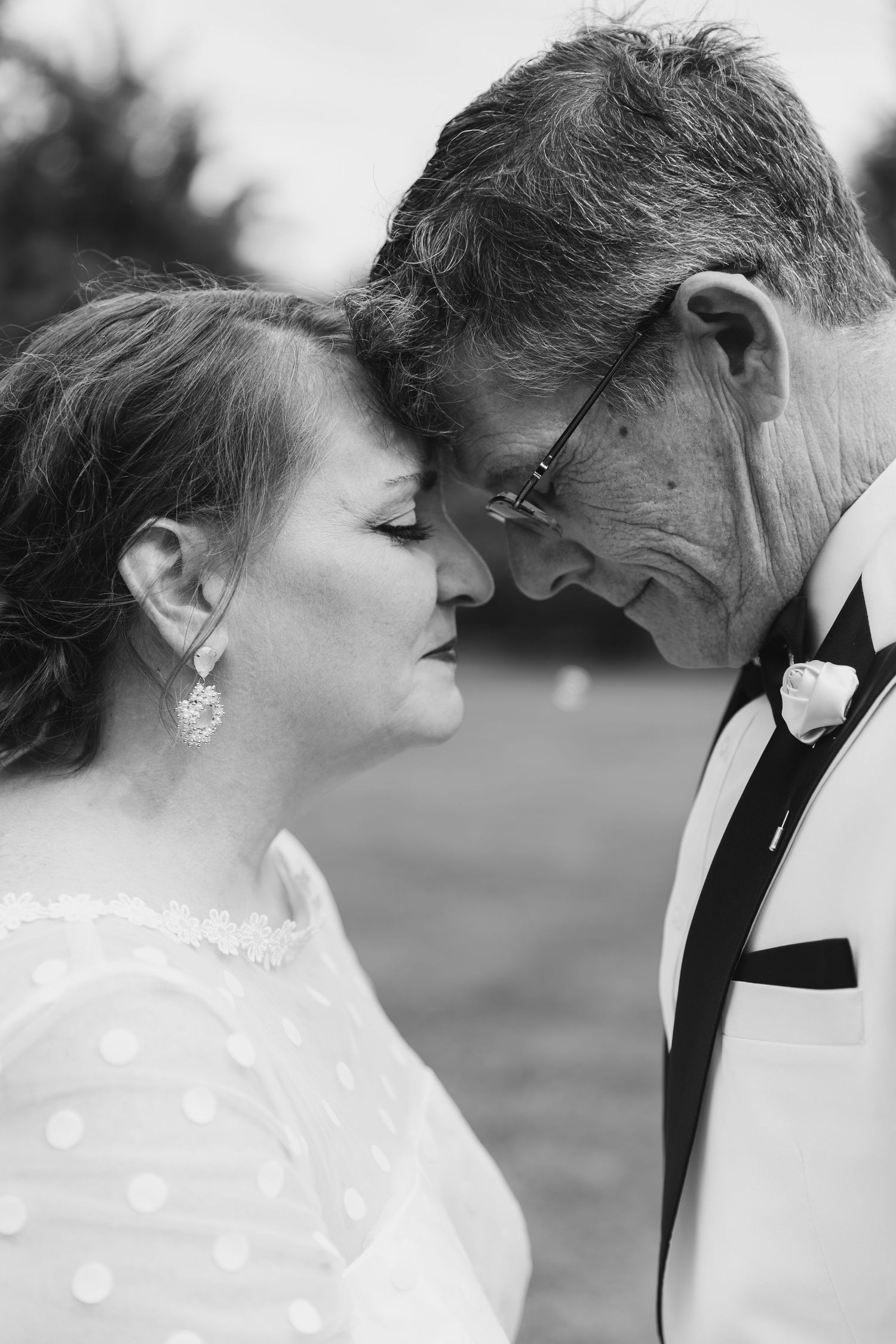 A romantic close-up black and white wedding portrait shows intimate newlyweds gazing at each other with affection and love.