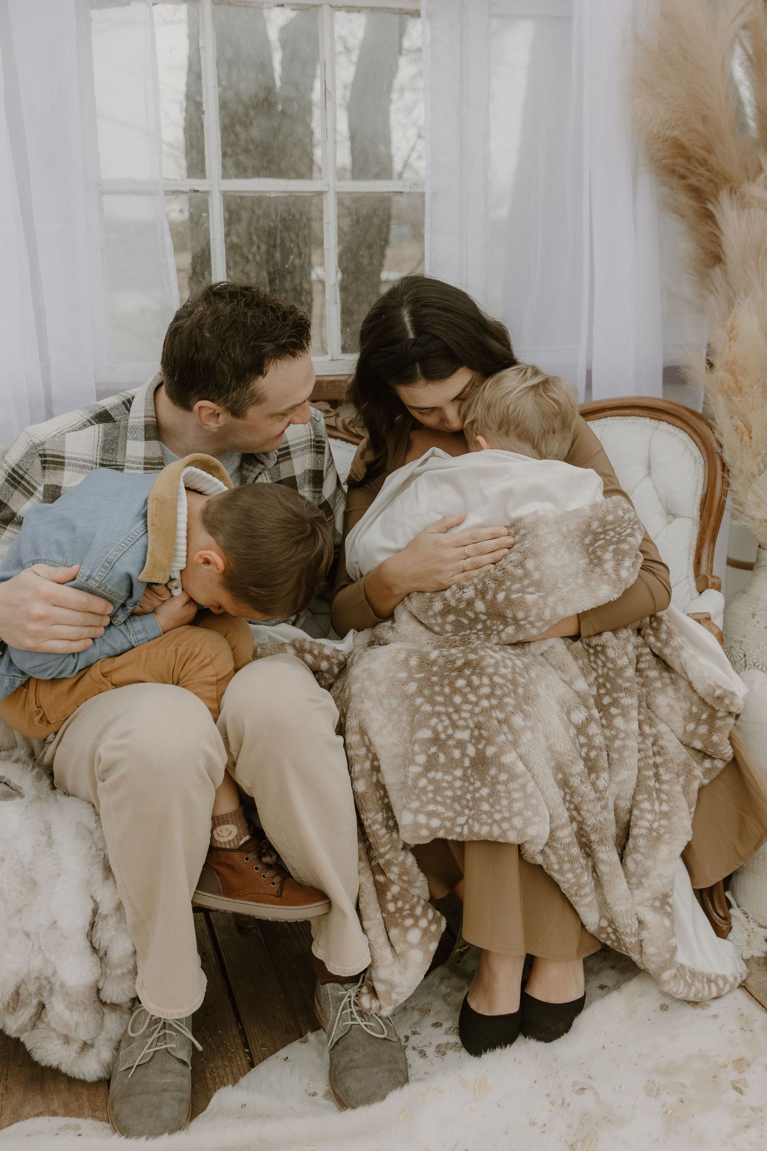 A series of four vintage-style photos showing a tender family moment with a spotted fawn on a couch.