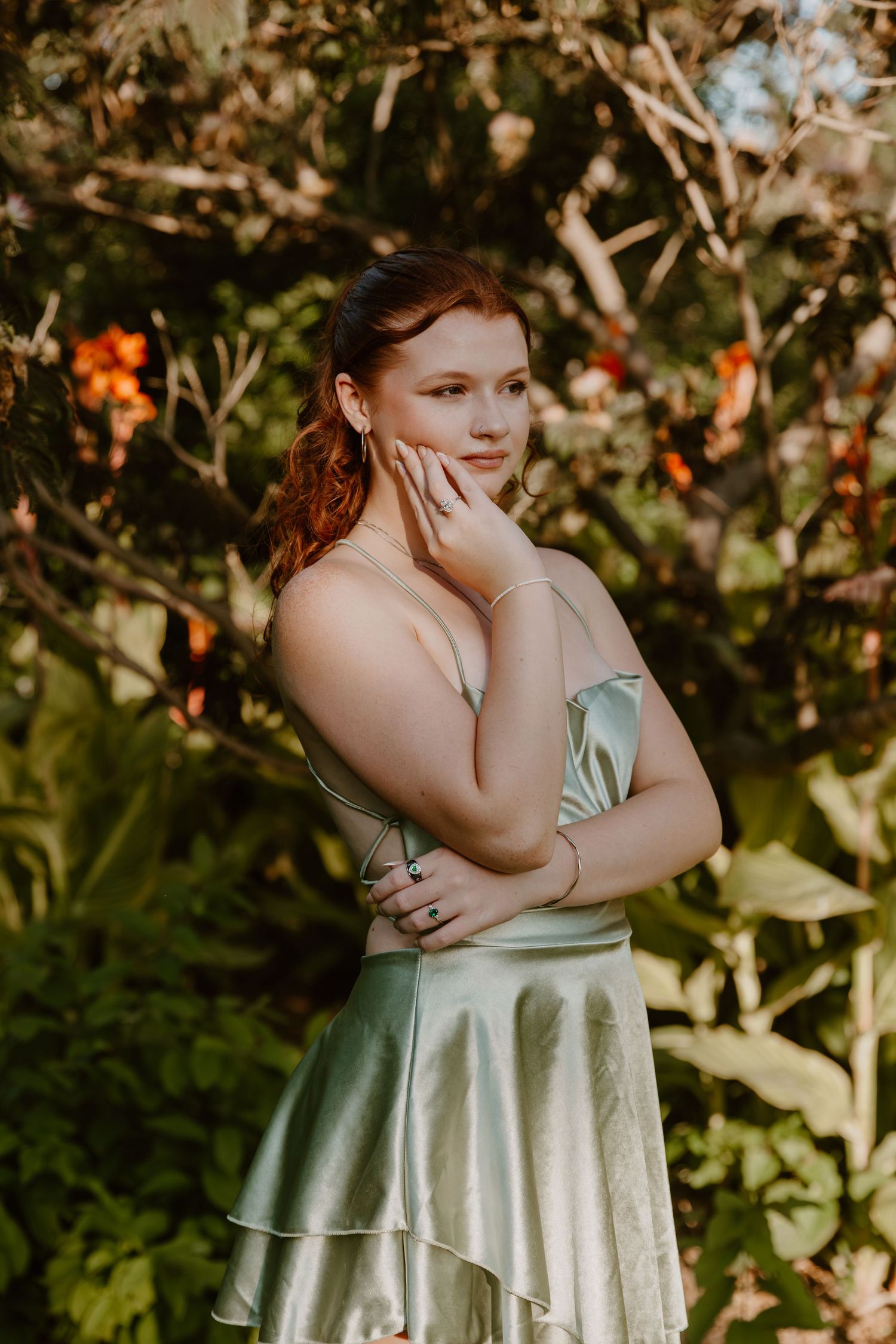 Romantic outdoor portrait in a garden with someone wearing a shimmering mint green satin dress at sunset.