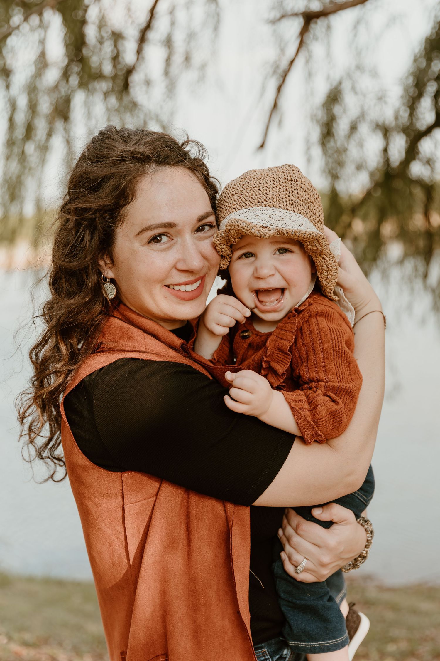 A heartwarming outdoor portrait showing joyful expressions and warm autumn colors, with a cute knit hat and orange clothing.