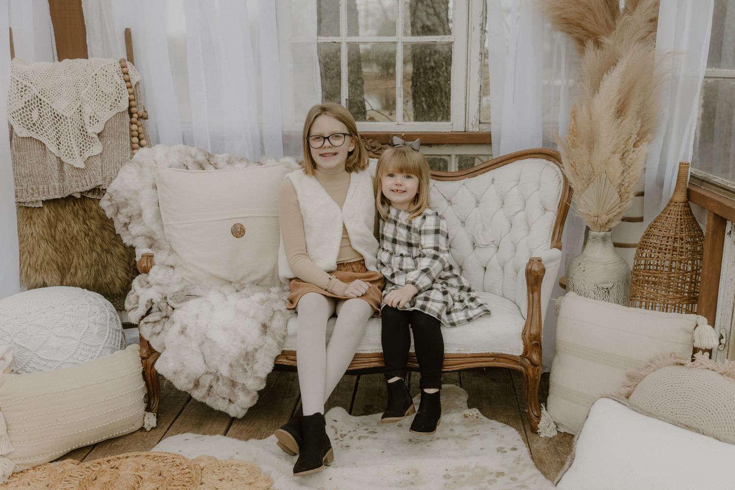 A cozy vintage living room scene with plush white furniture and natural decor elements in warm, muted tones.