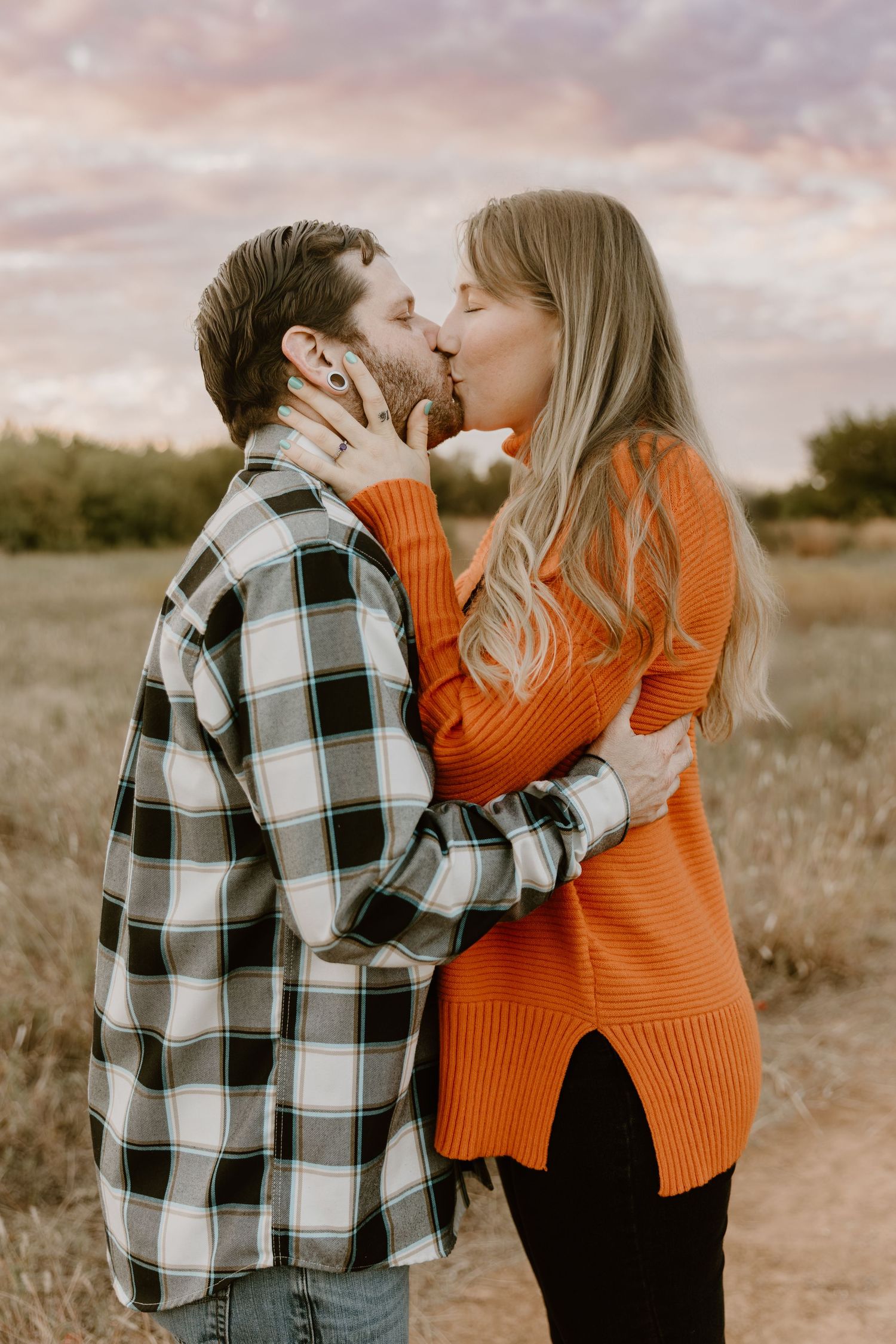 A couple in a plaid shirt and orange sweater share intimate moments in a series of desert landscape photos.