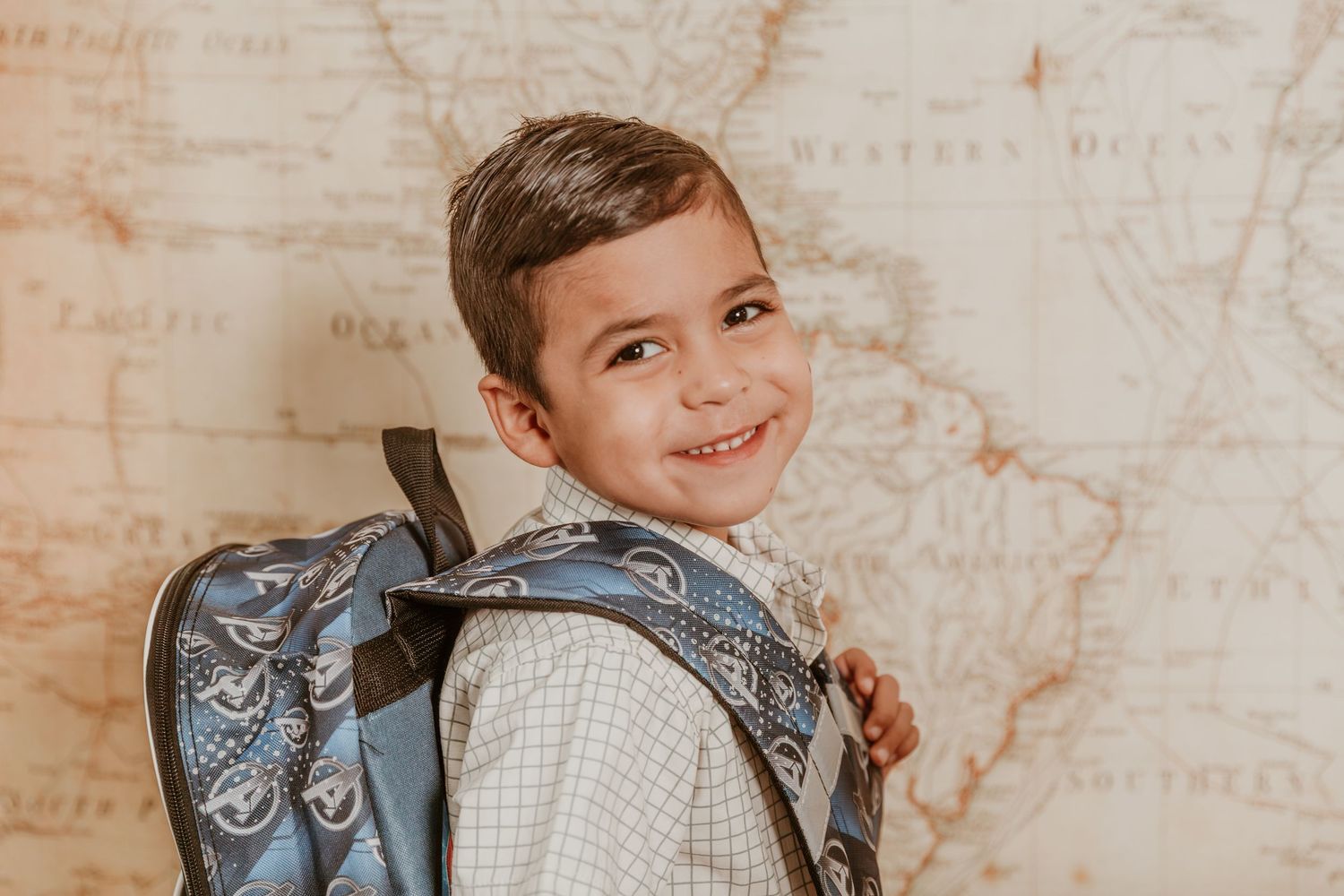 Student wearing a backpack in front of a textured background.
