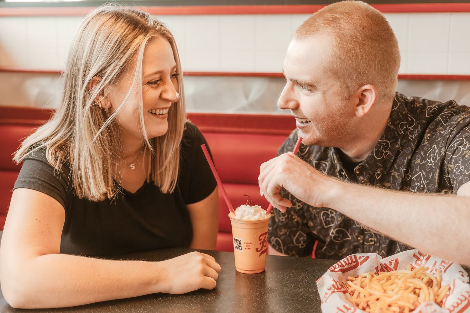 A couple enjoys ice cream and pasta while dining together at a restaurant.