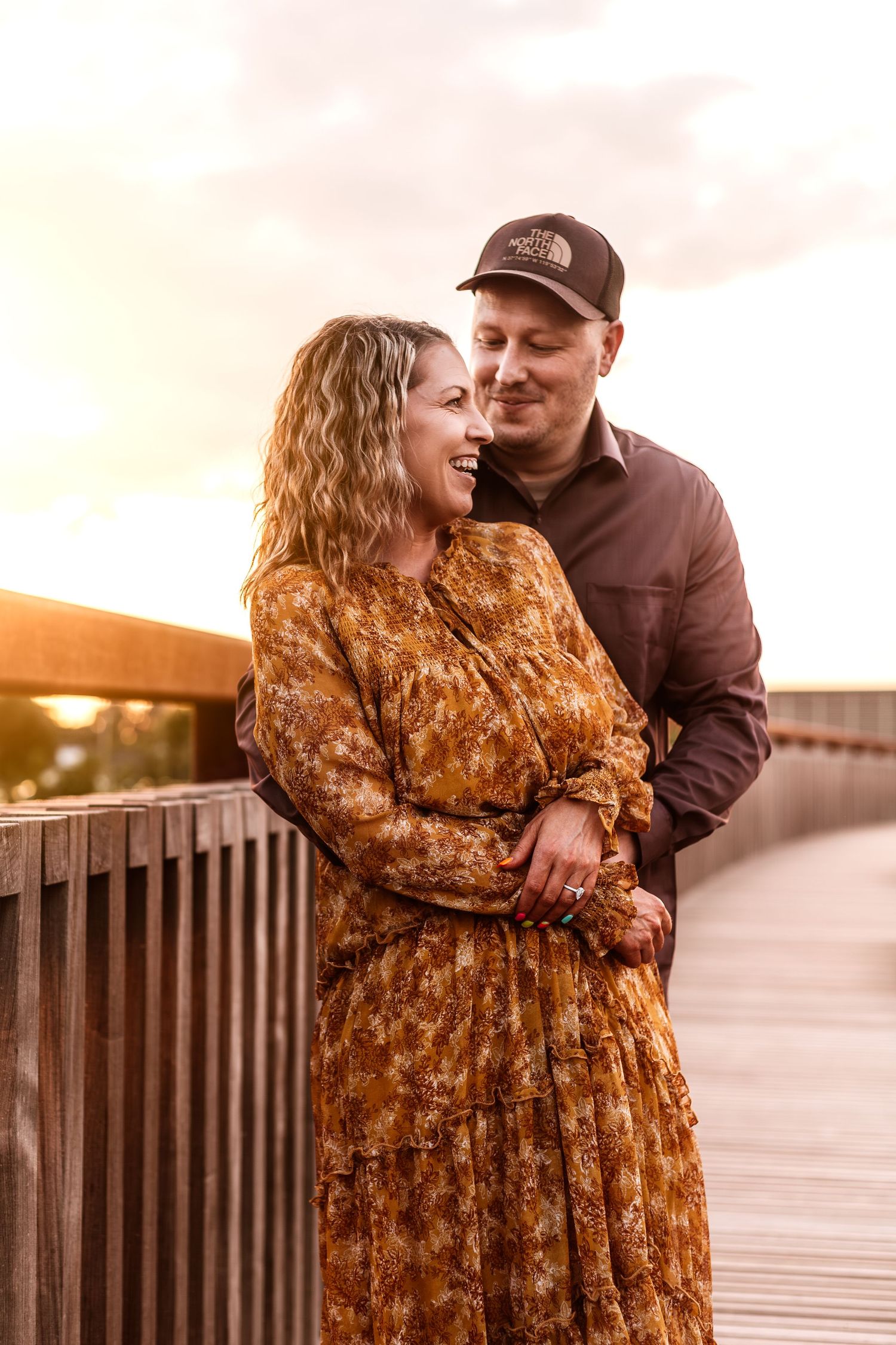 A sunset moment on a wooden bridge with warm autumn colors and intimate embrace.