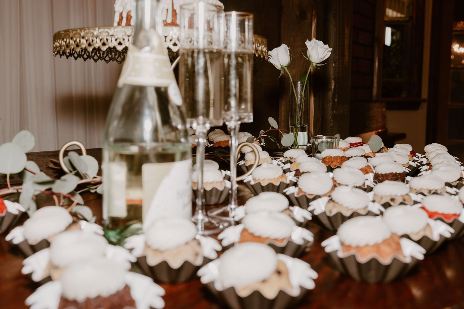 Crystal chandeliers and delicate hanging lights create an elegant ambiance in a romantic indoor wedding reception venue.