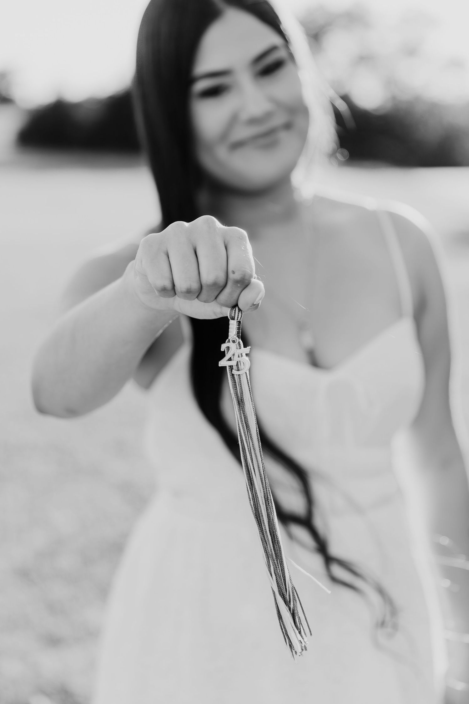 A series of black and white photos showing hands delicately holding dangling tassel earrings.