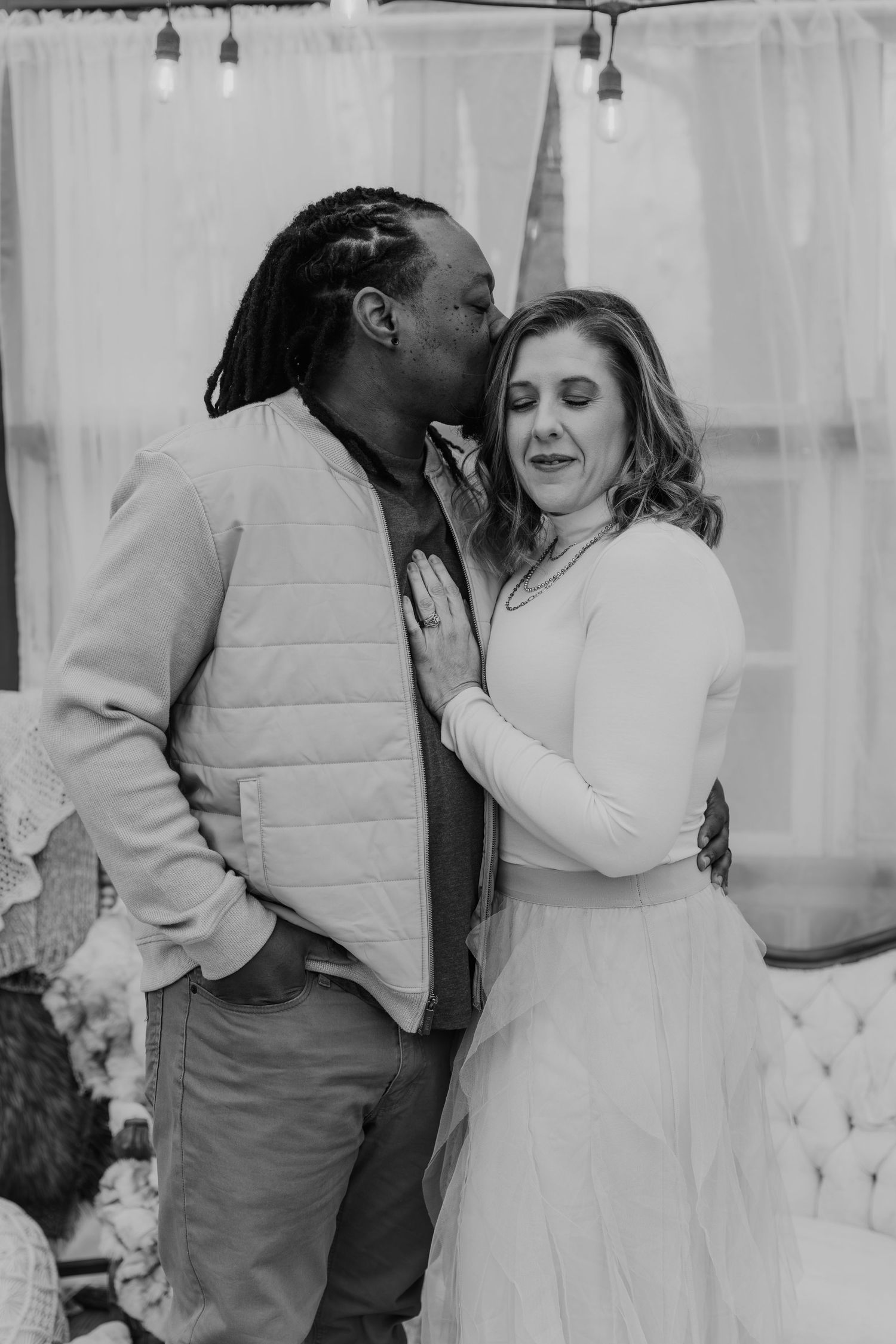 A series of romantic black and white photos showing a couple embracing and dancing together in an intimate moment.