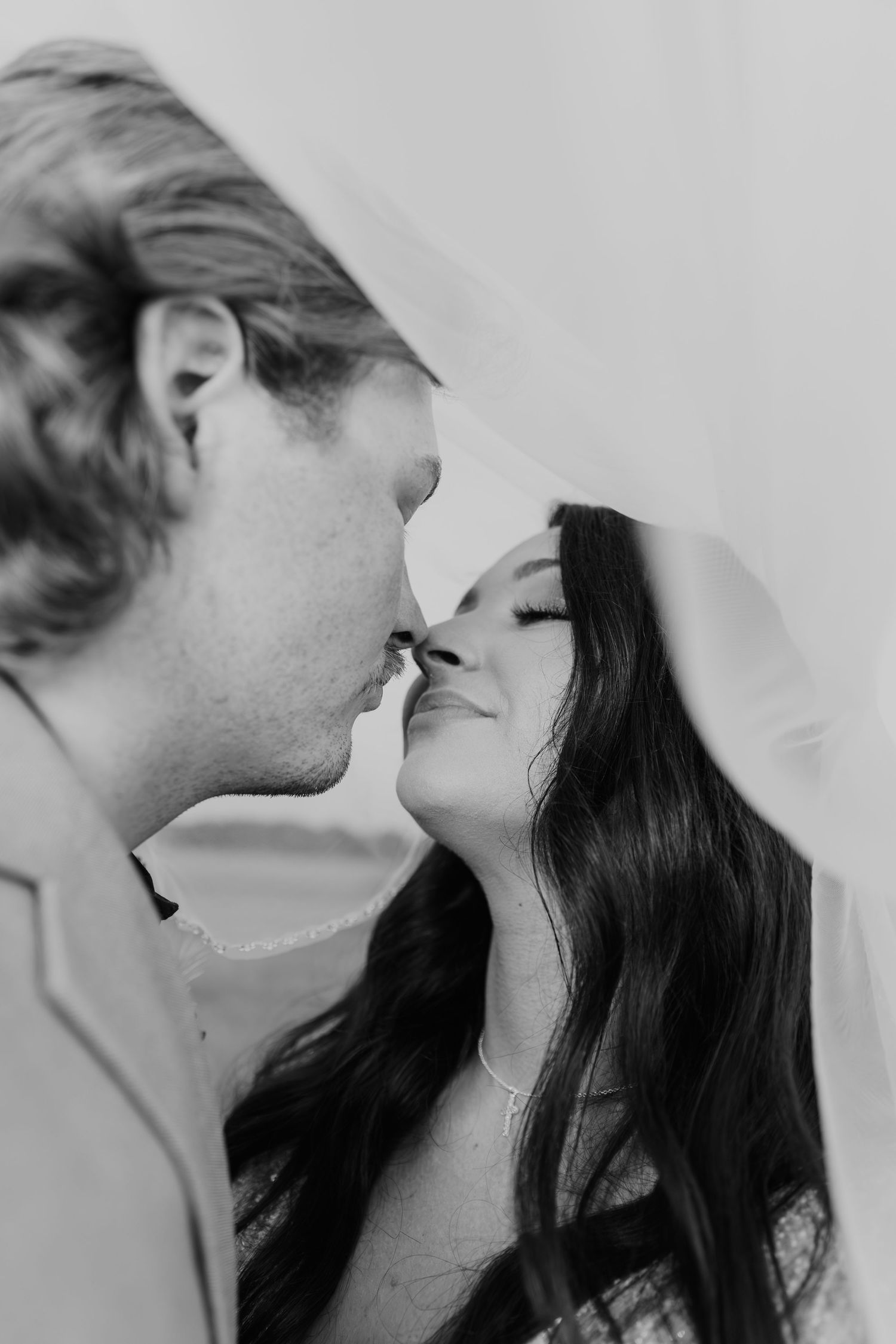 A romantic black and white photo series showing a couple sharing intimate kisses from different angles.
