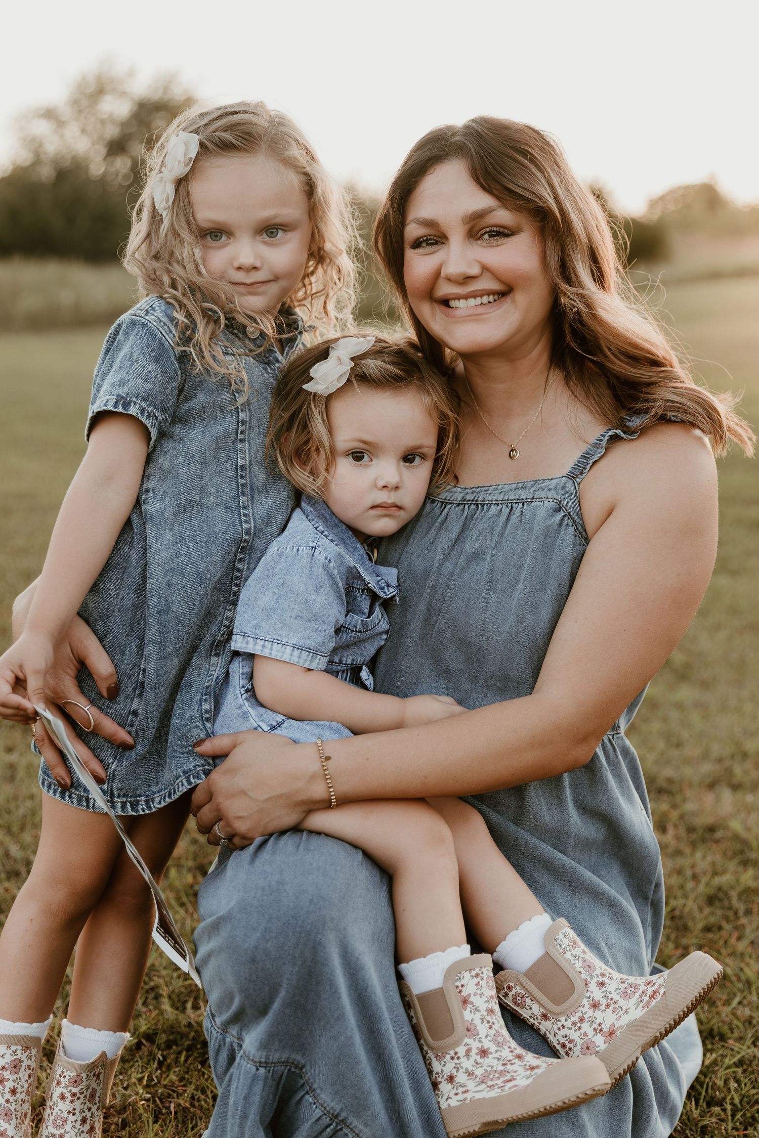 Mother and daughter in matching denim outfits share sweet candid moments together in an outdoor photoshoot.