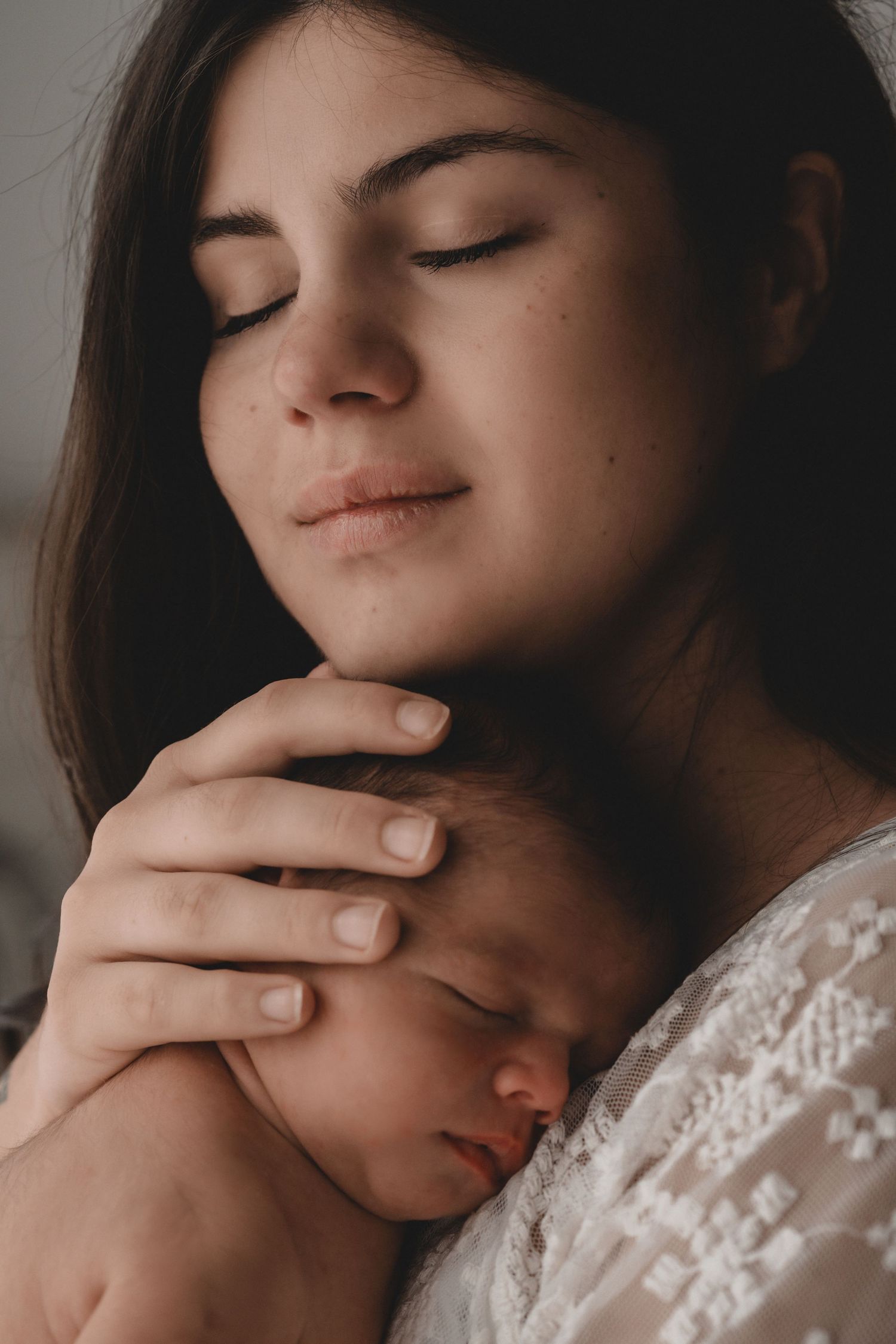 A series of intimate portraits showing a person in a white lace dress with closed eyes in various poses.