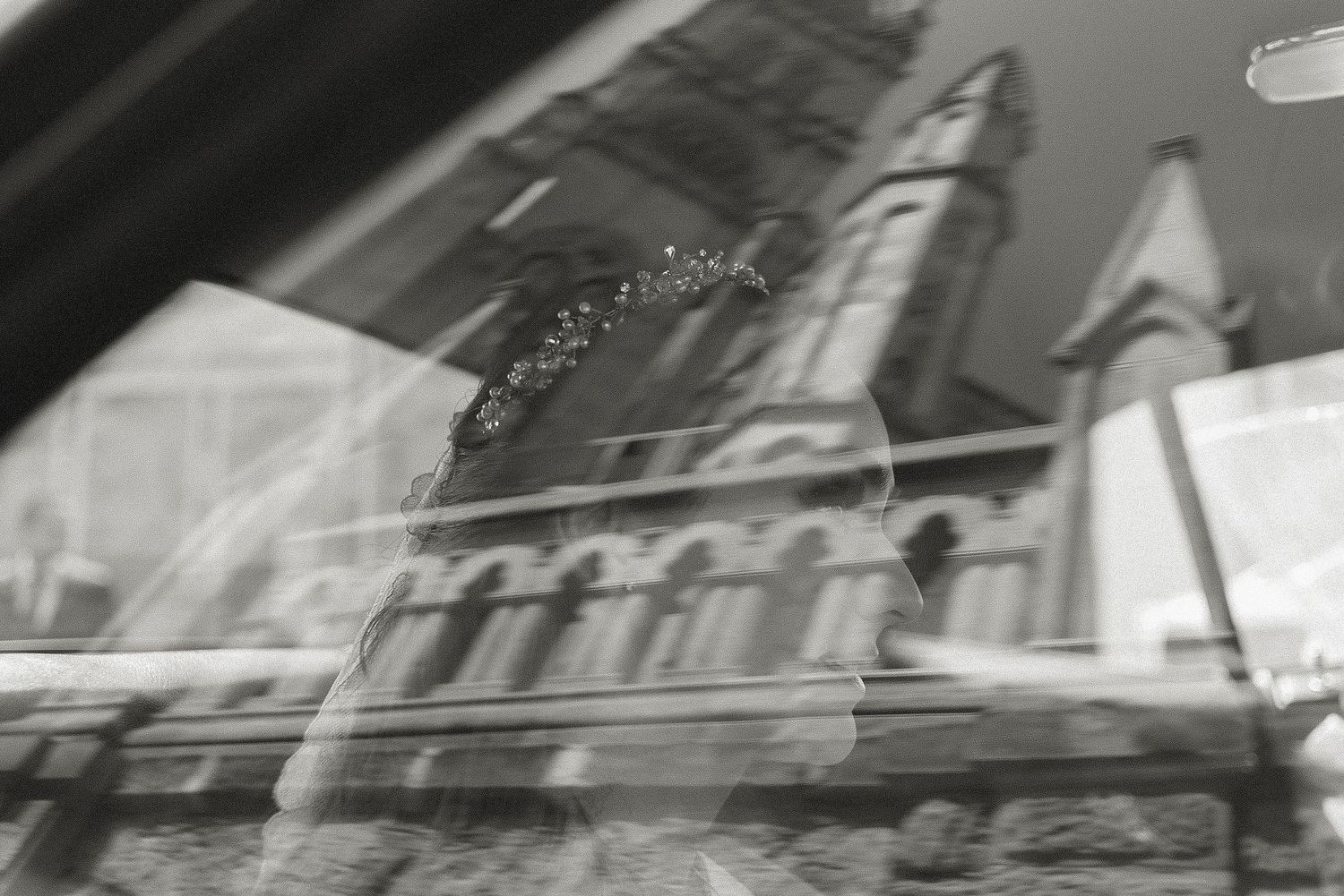 Black and white artistic wedding photograph with architectural elements in motion blur.