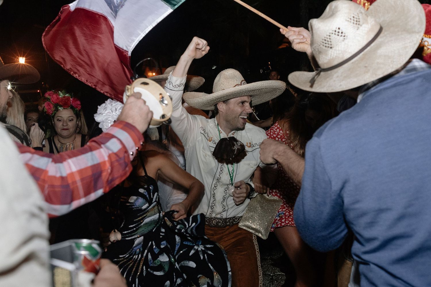 People crowd together energetically dancing at what appears to be a country western dance party.
