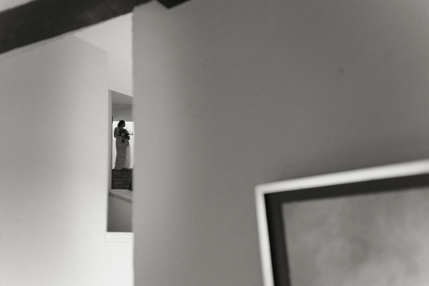A small decorative statue or figurine is displayed in a white wall niche, creating a minimalist architectural detail.