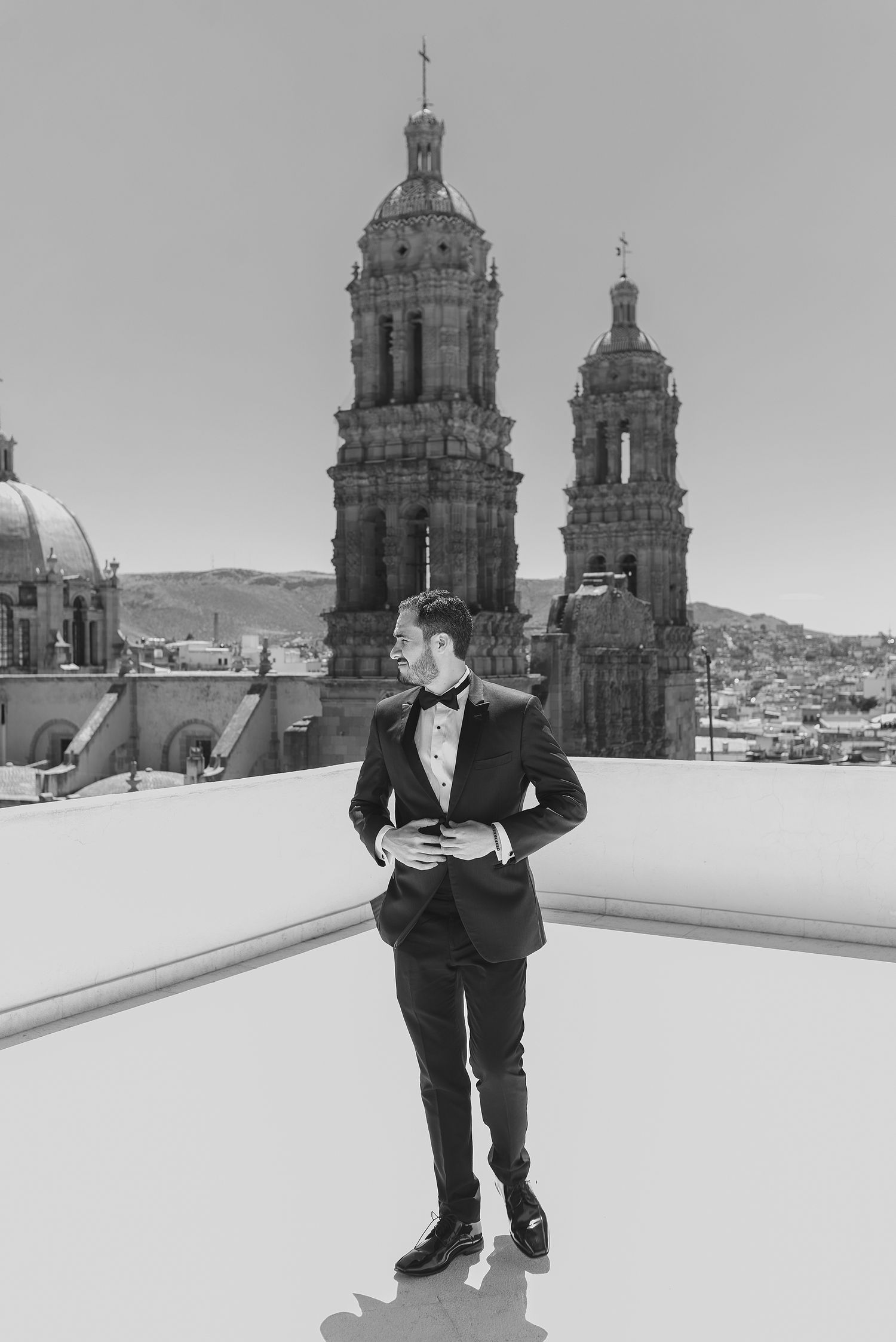 Classic black and white photo of formal wear against Mexican cathedral architecture.