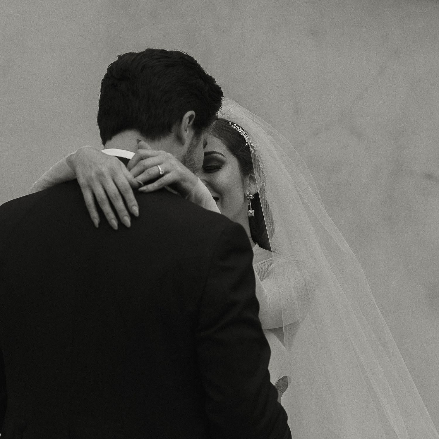 Intimate black and white portrait of wedding couple embracing.