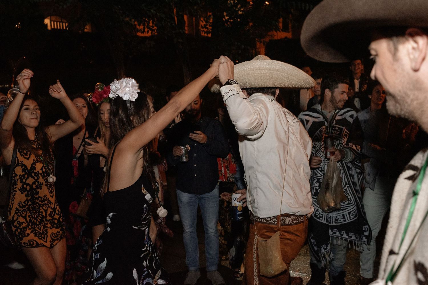 People dancing enthusiastically at a nightclub party with raised arms and lively crowd in the background.