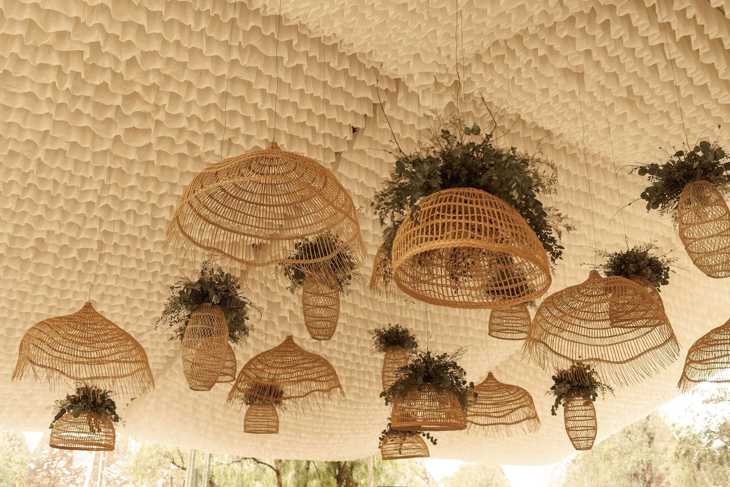 Decorative woven basket light fixtures hang from a textured ceiling in a rustic restaurant interior.