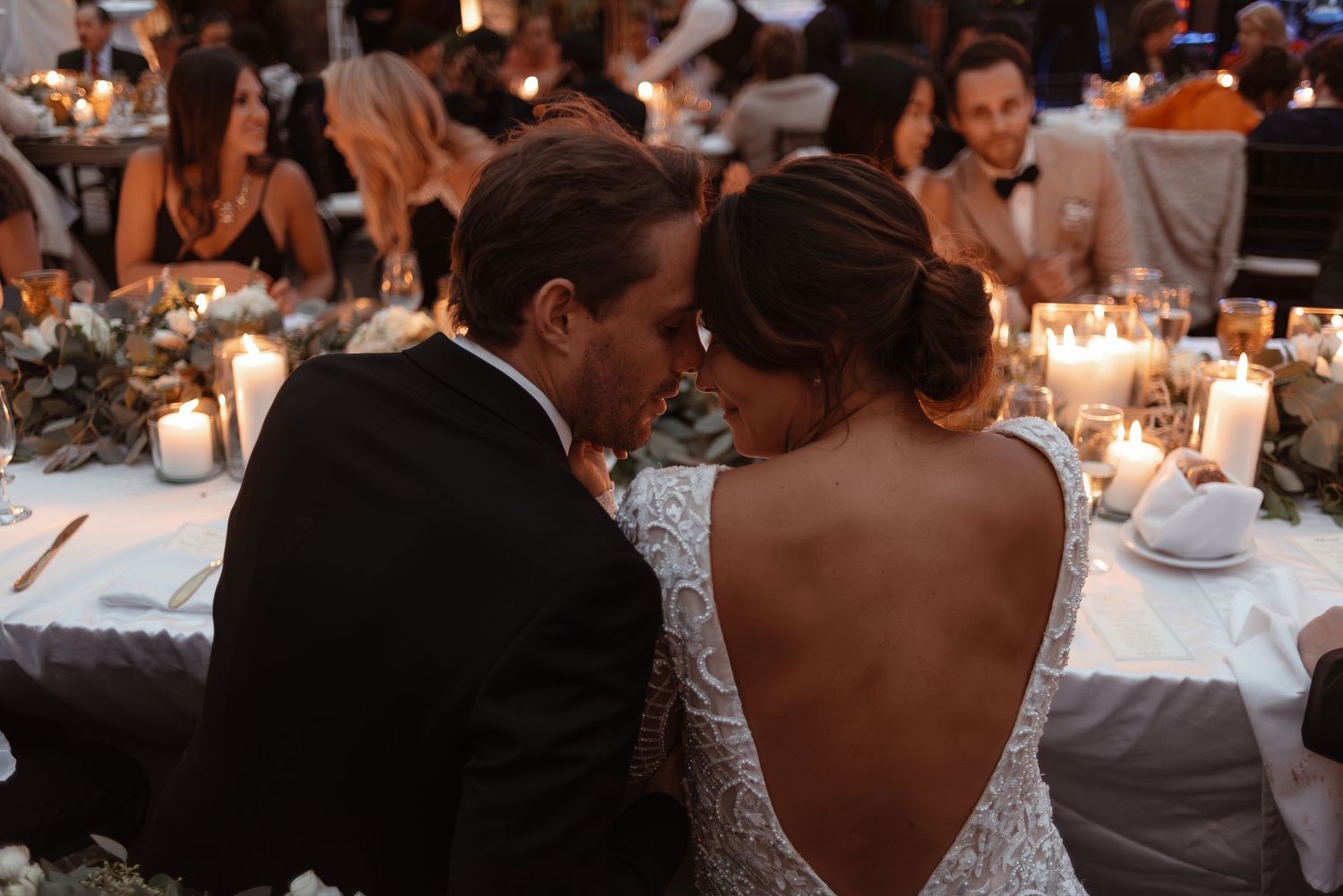 Intimate moment at wedding reception with candlelit table setting.