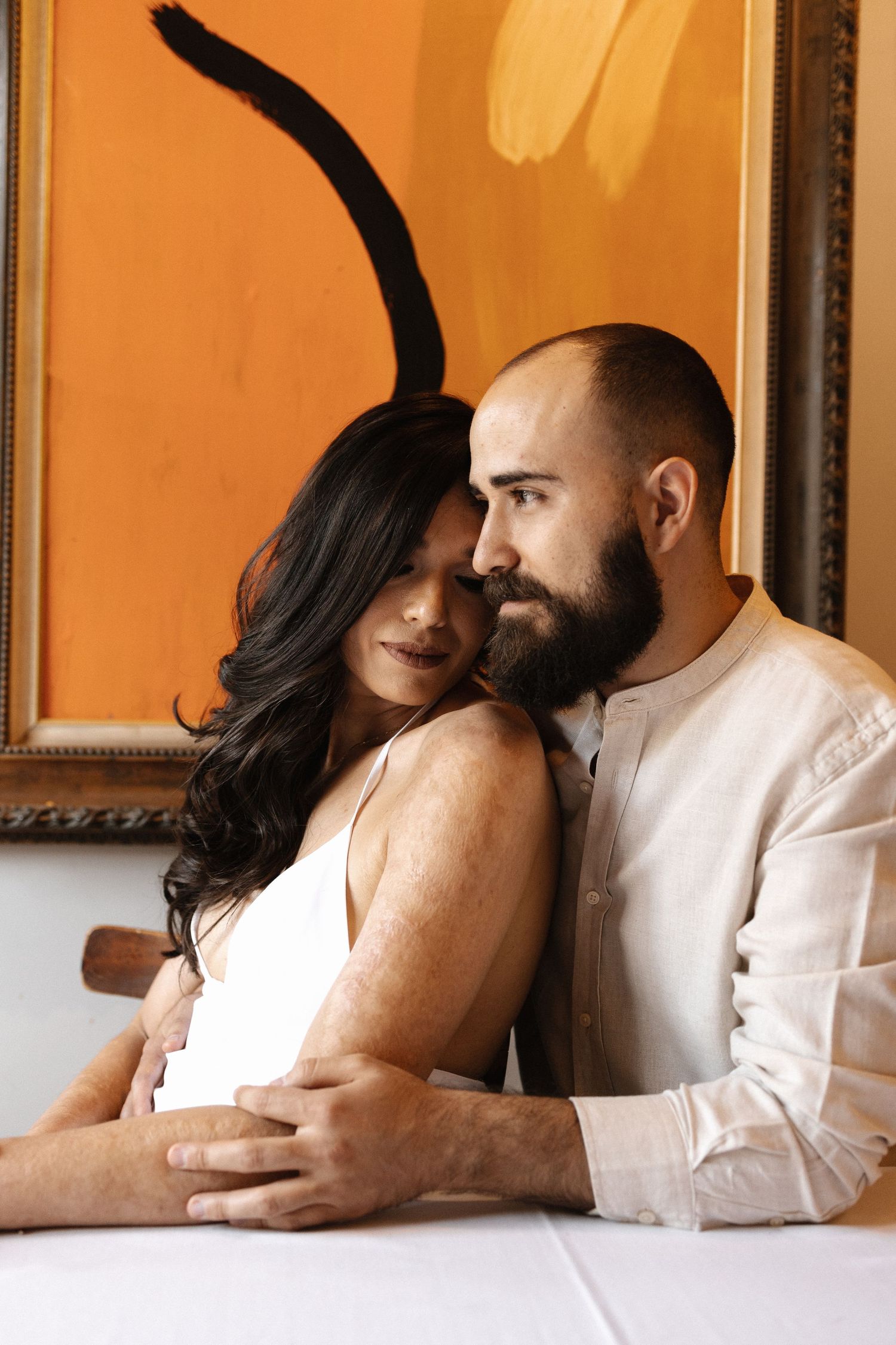 A romantic sequence of photos showing a couple lying down and embracing in warm lighting.