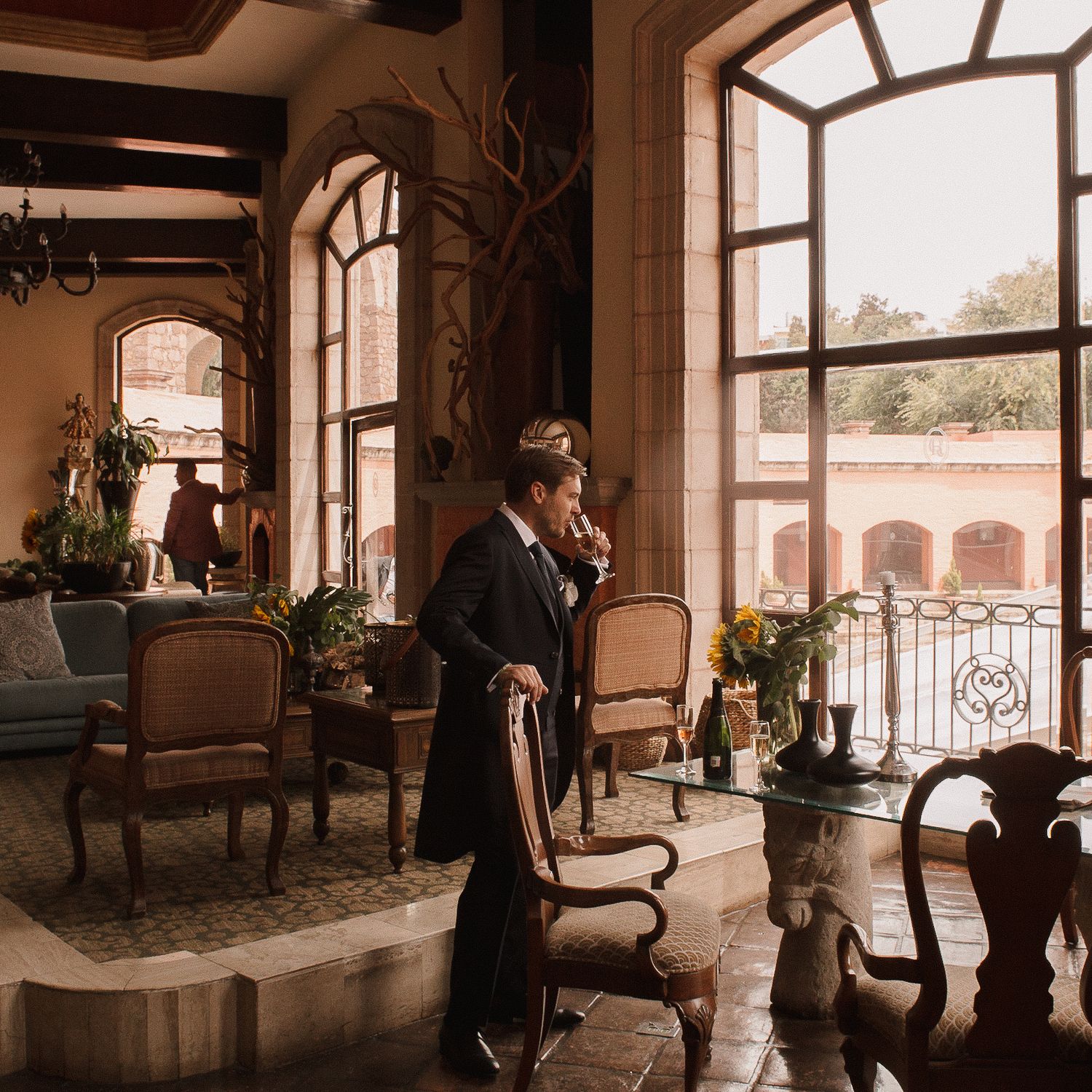 Panoramic view of an elegant indoor venue with arched windows and classic furniture.