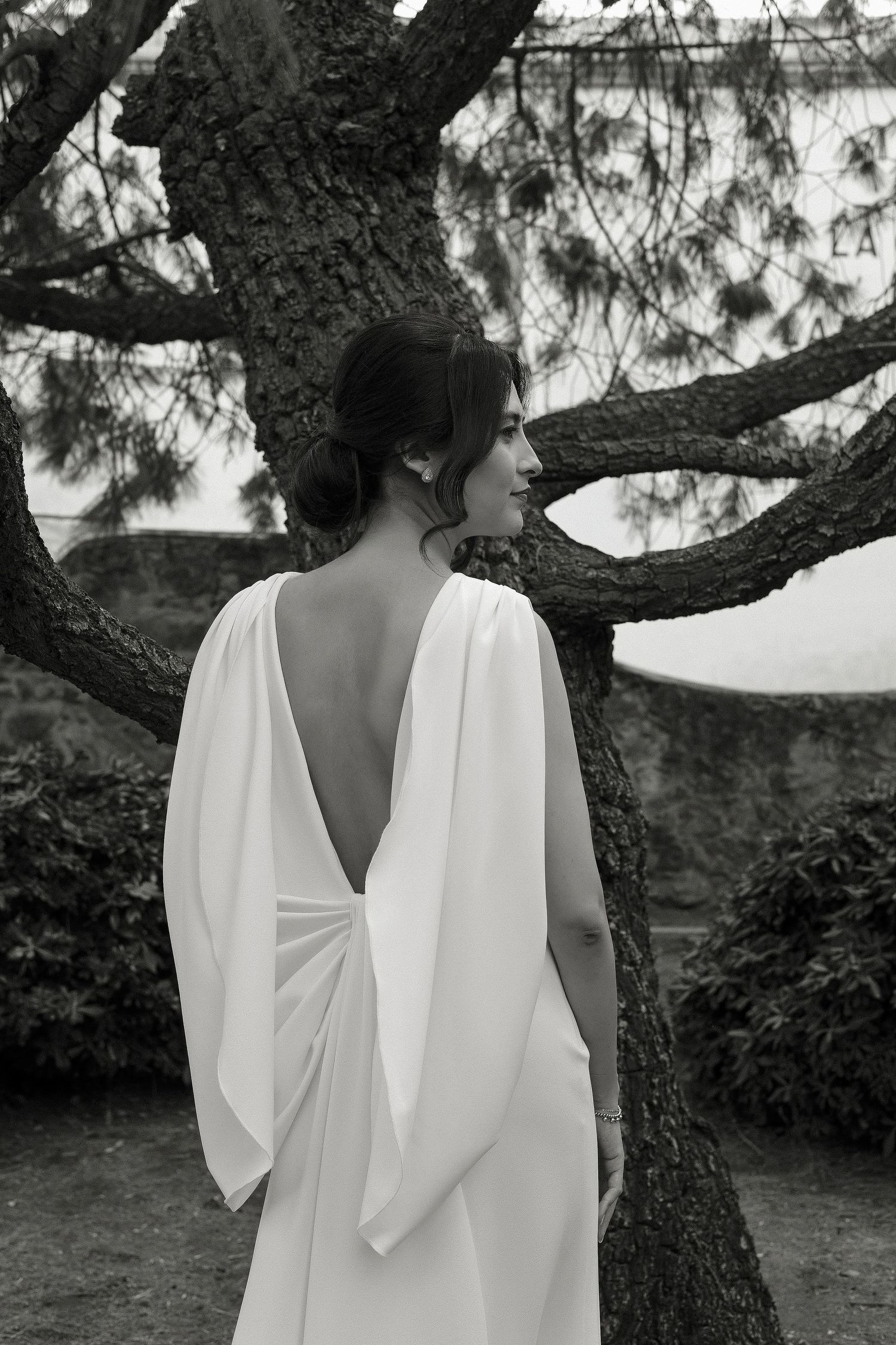 Black and white artistic photo series showing a flowing white dress against a natural garden backdrop.