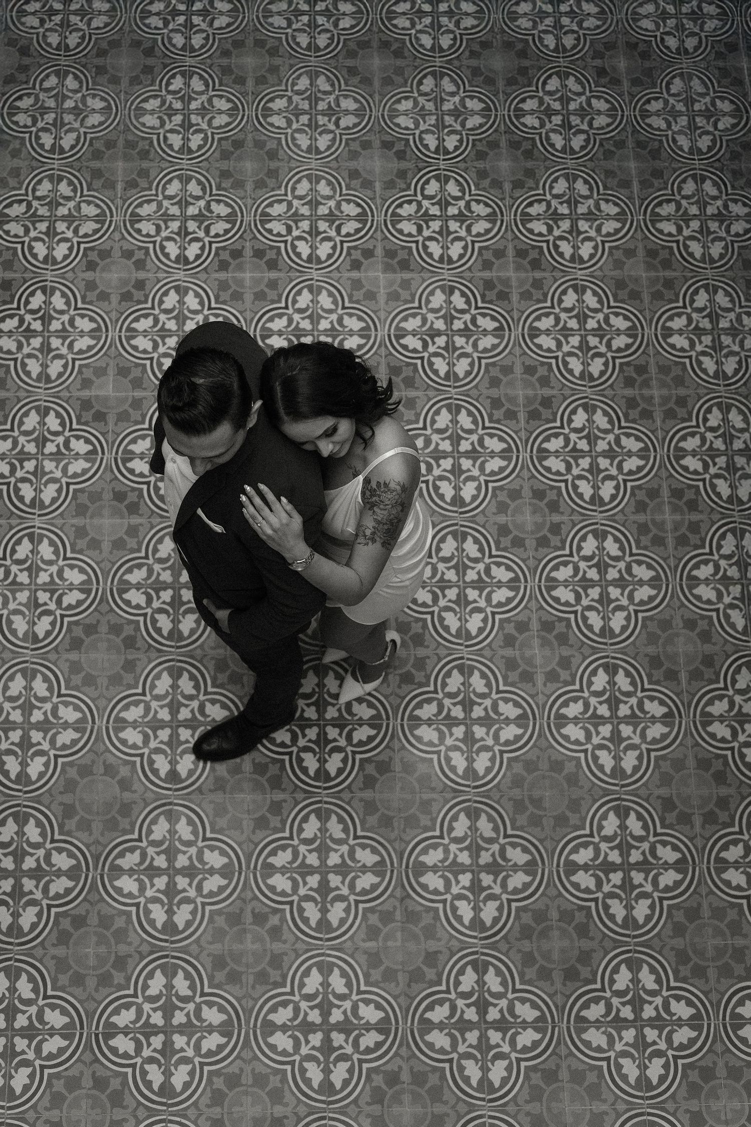 A black and white triptych showing a couple dancing intimately on a decorative tiled floor.