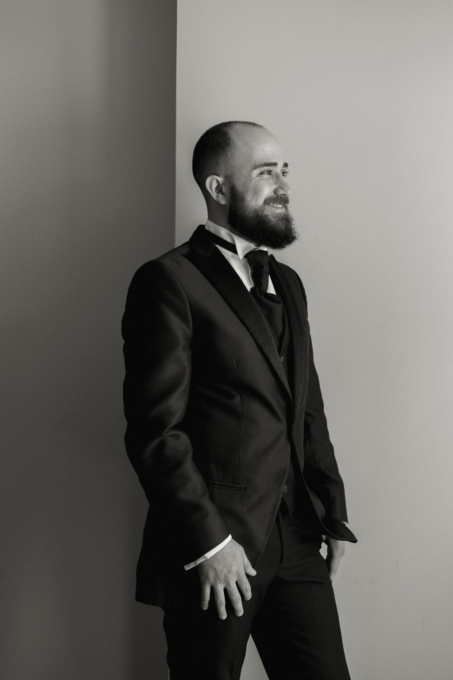 Black and white portrait series showing a person in a dark suit against a light background in different dynamic poses.