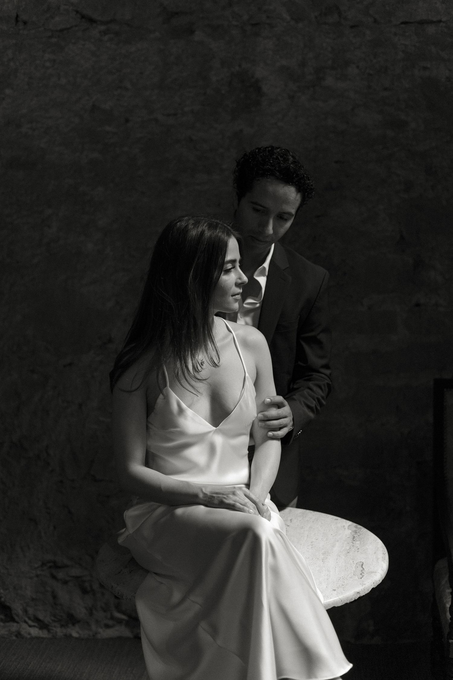 Black and white artistic wedding portraits showing romantic moments between a couple in formal attire.
