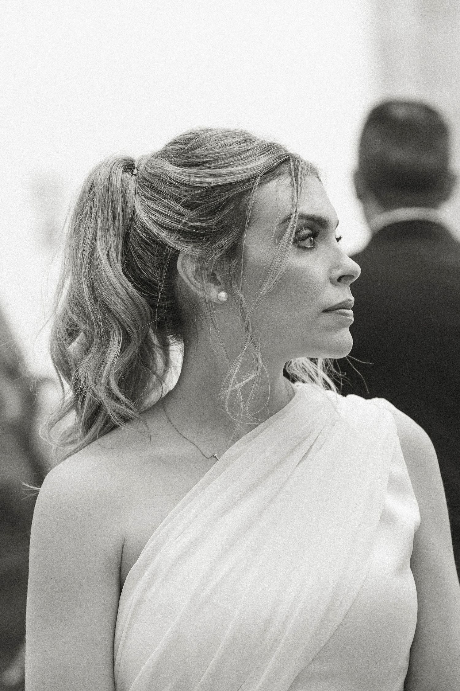 A series of profile views showing a woman in a white one-shoulder dress with an elegant updo hairstyle.
