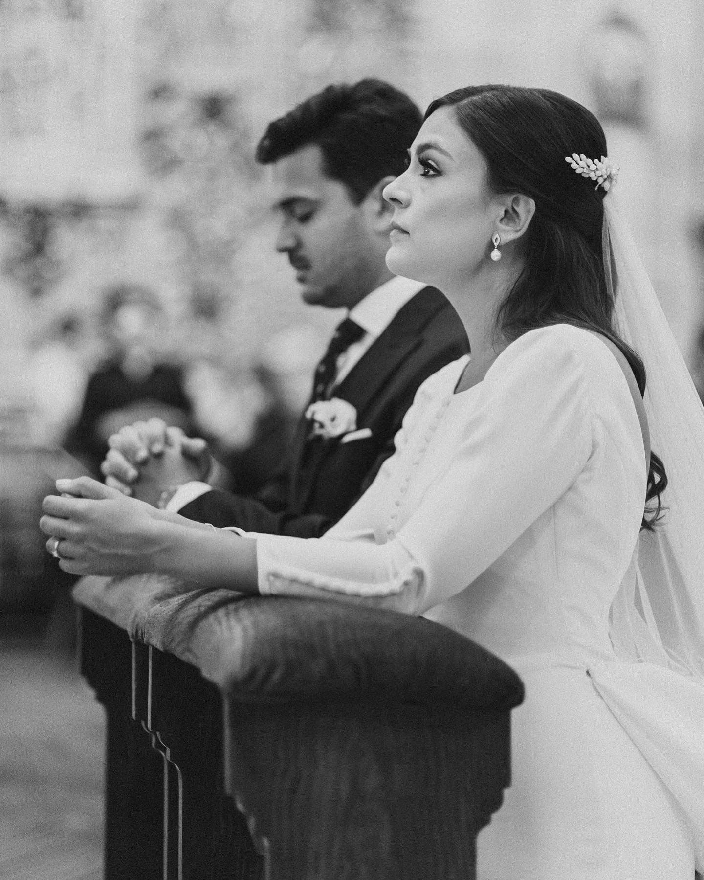 Black and white photo of couple at church altar during wedding ceremony.