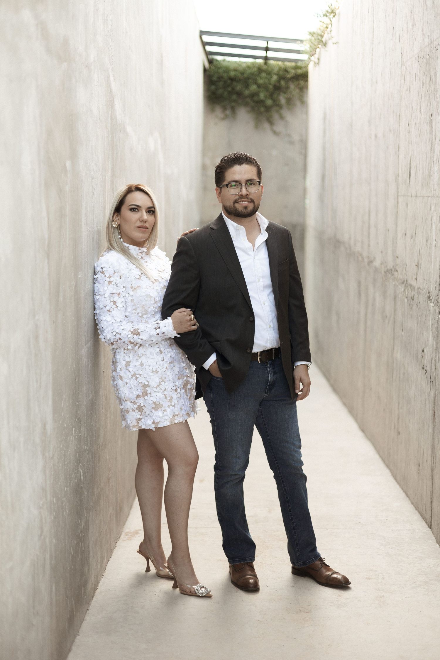 Three similar photos show a couple in formal attire standing in a white concrete corridor.