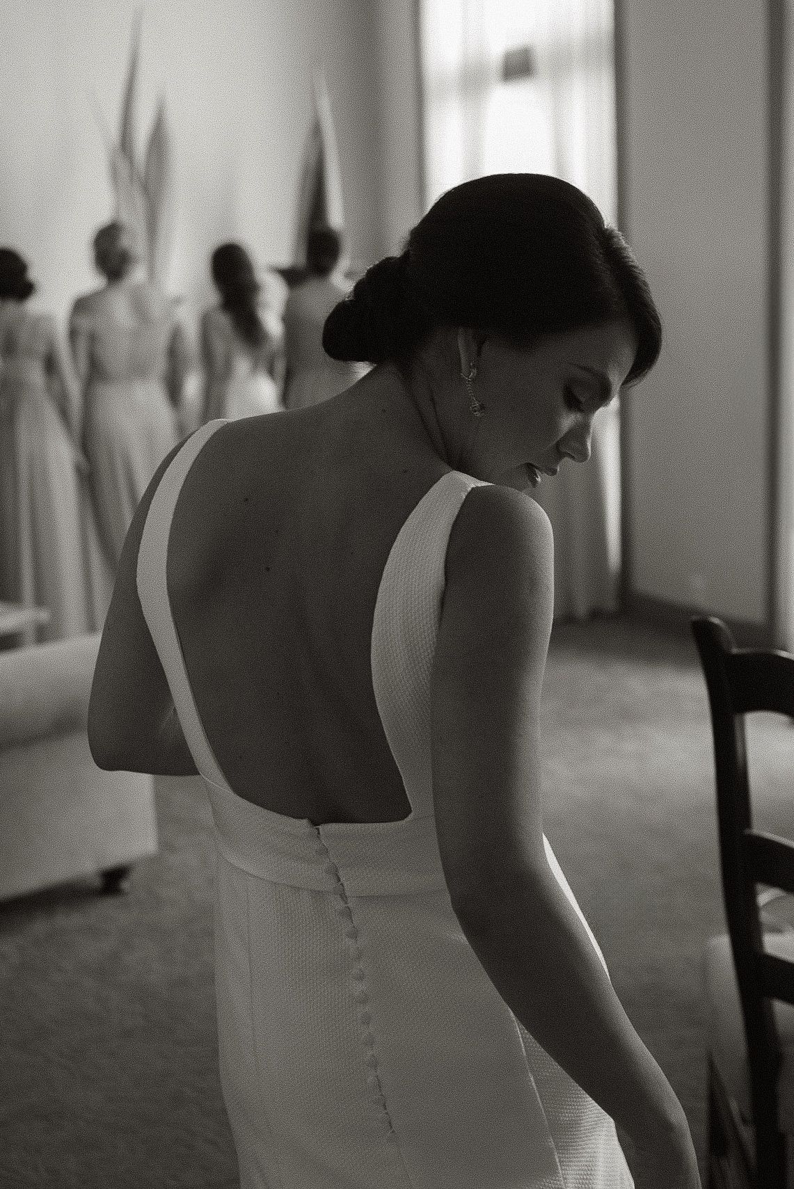 Black and white photo showing the back detail of a fitted wedding dress.