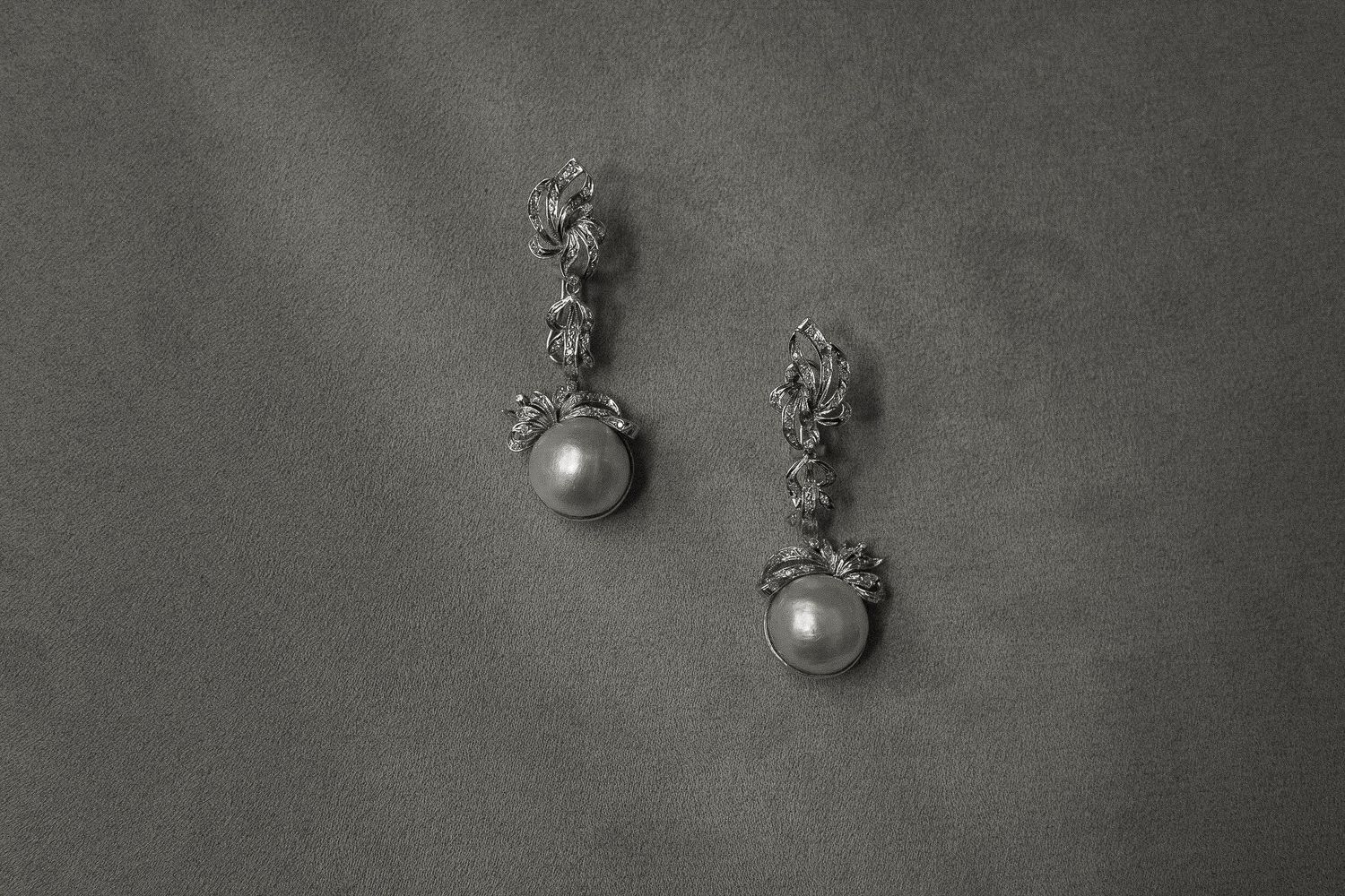 Decorative wall sconces with ornate details against a gray textured background.