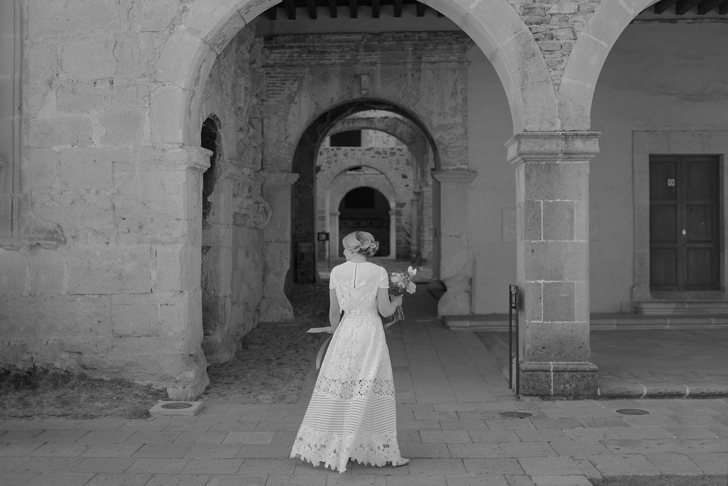 A series of elegant archways in a historic stone building with soft natural lighting.