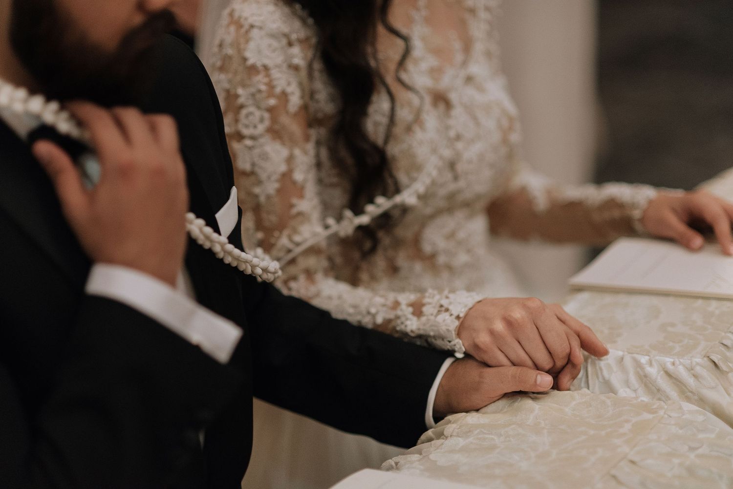 Elegant close-up details of a bride and groom signing their marriage certificate during an intimate wedding ceremony.