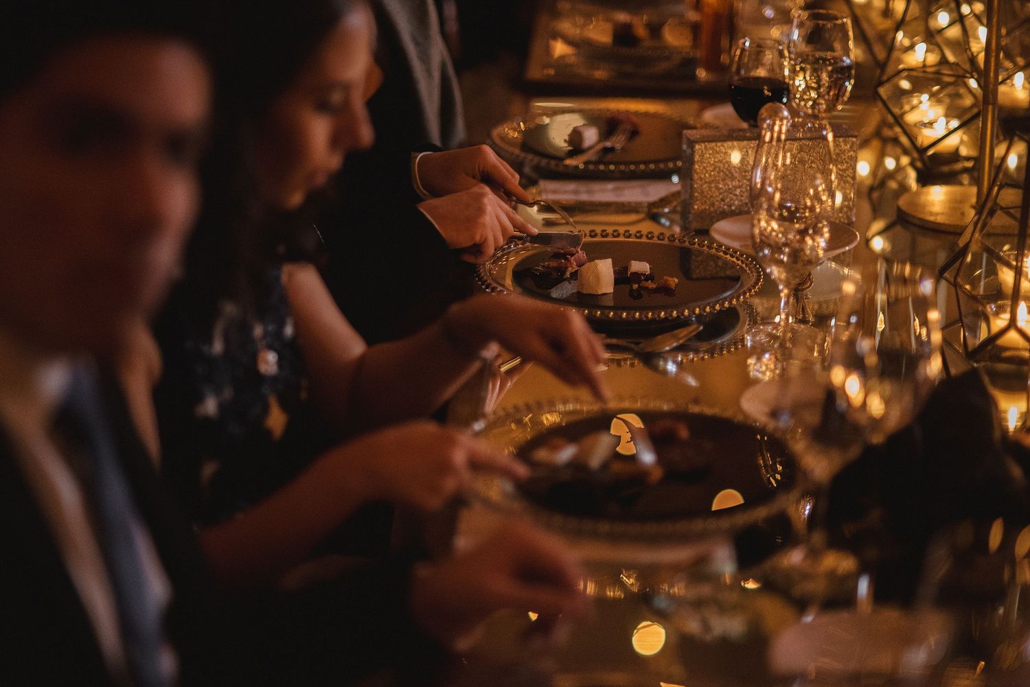 Warm candlelit reception tables set for an elegant evening wedding celebration.