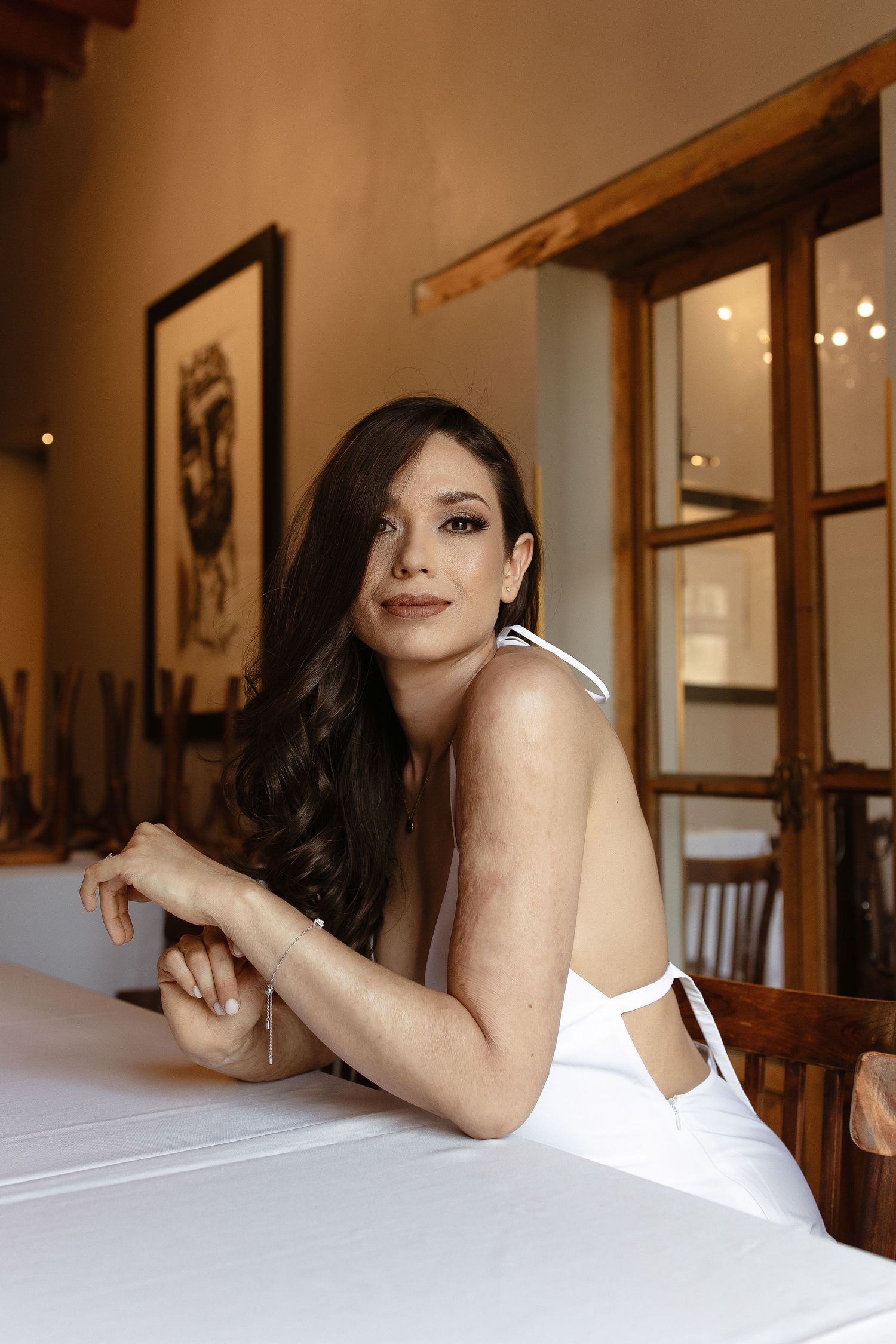 A series of photos showing someone in a white top reclining on a bed in a warmly lit room with wooden decor.